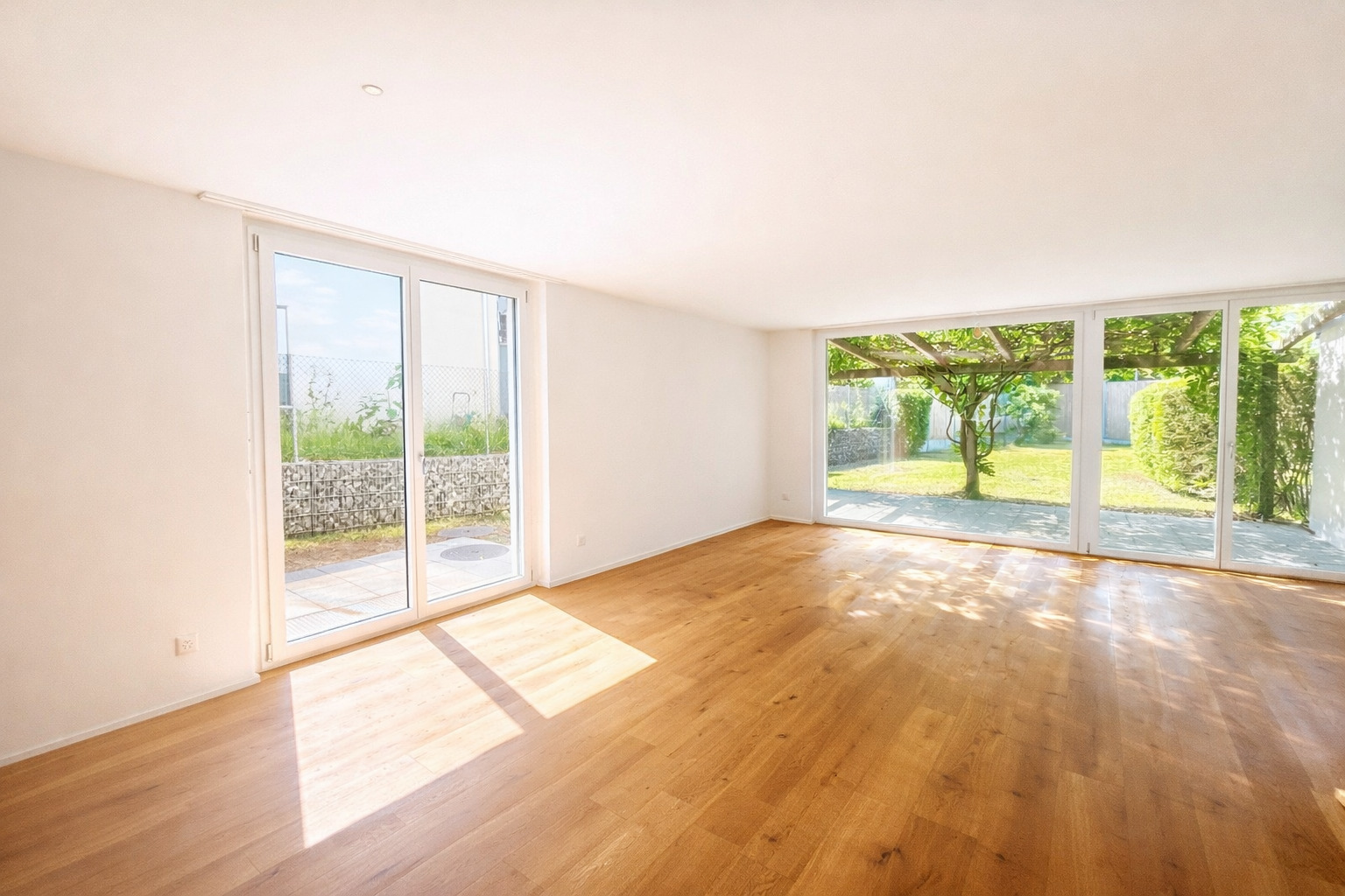 Heller leerer Wohnraum mit Gartenblick