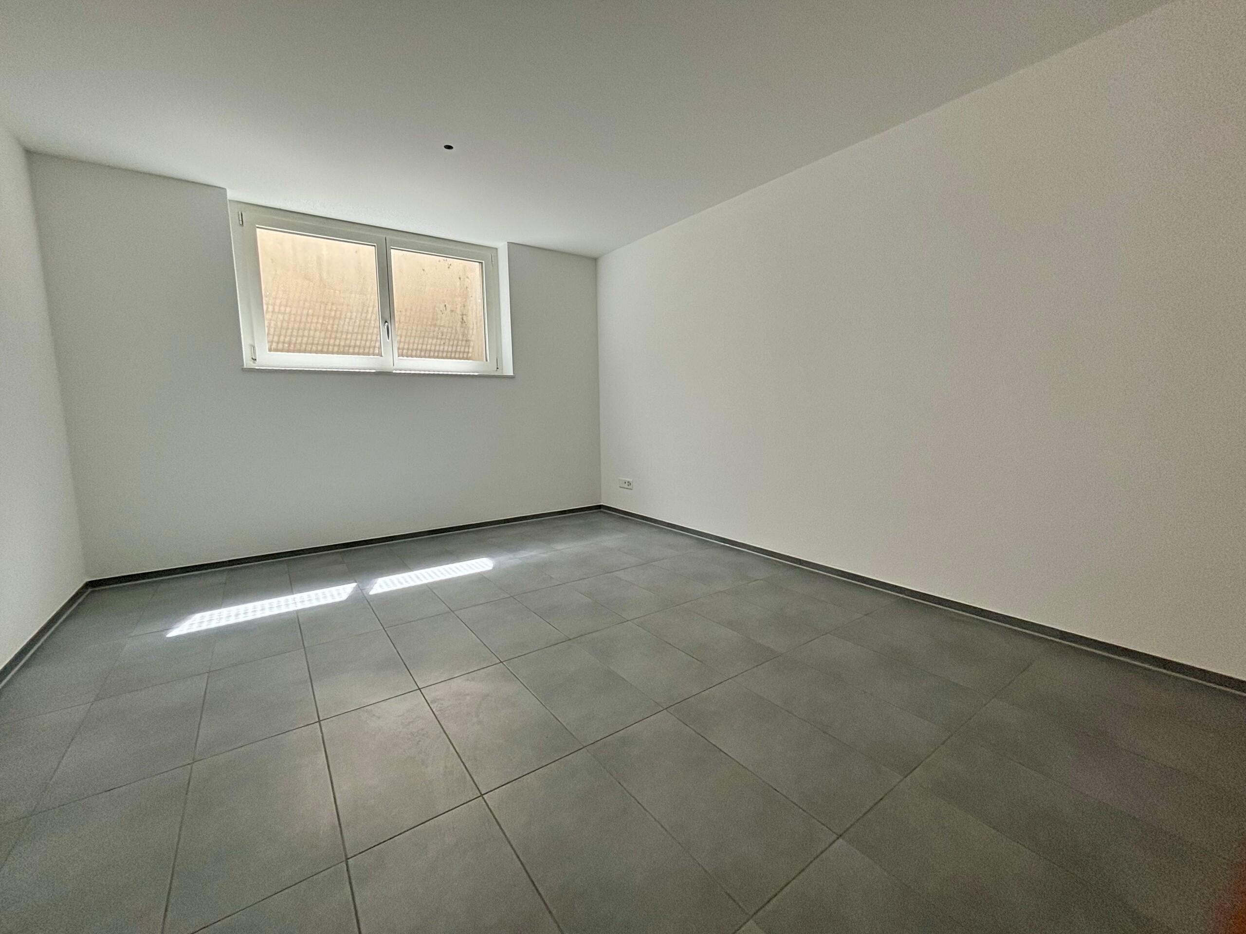 Leerer, modern wirkender Raum mit Fenster