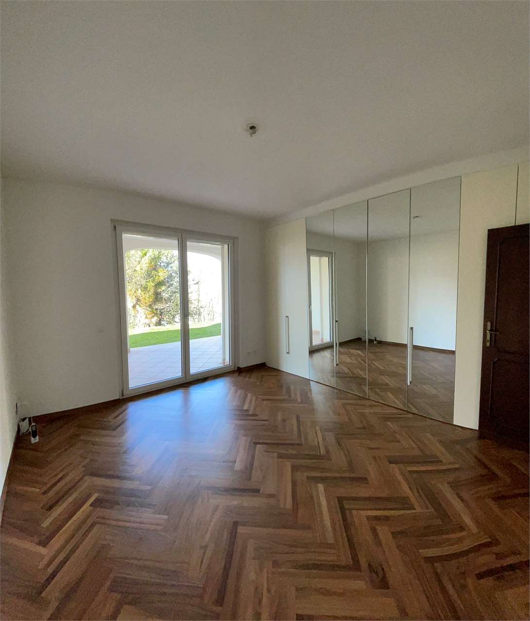 Leeres Schlafzimmer mit Einbauschrank und Balkonzugang