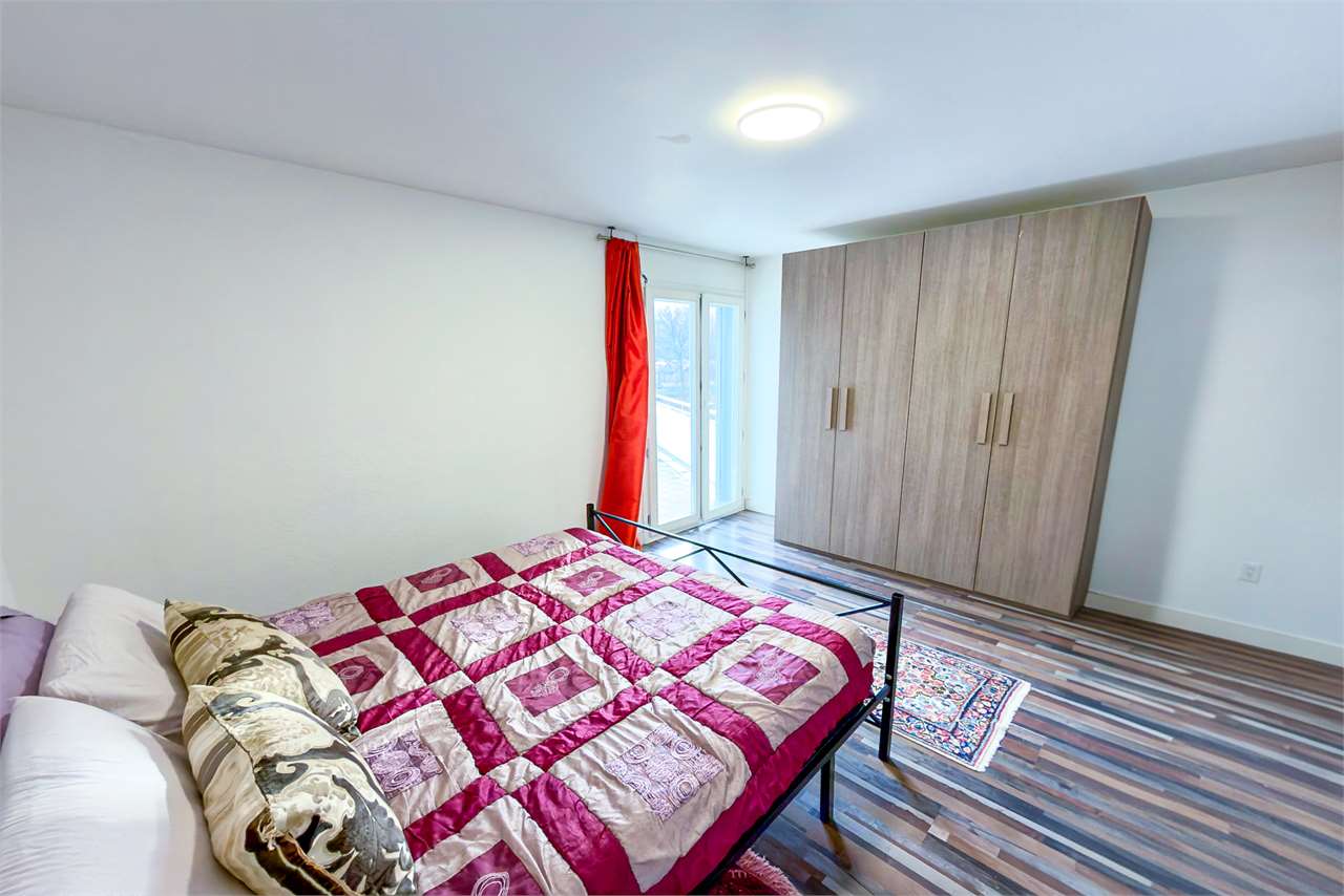 Helles Schlafzimmer mit Bett und großem Kleiderschrank