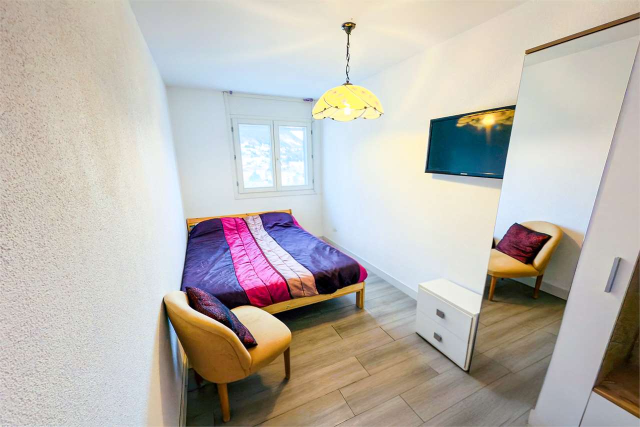 Kleines Schlafzimmer mit Einzelbett und Spiegel