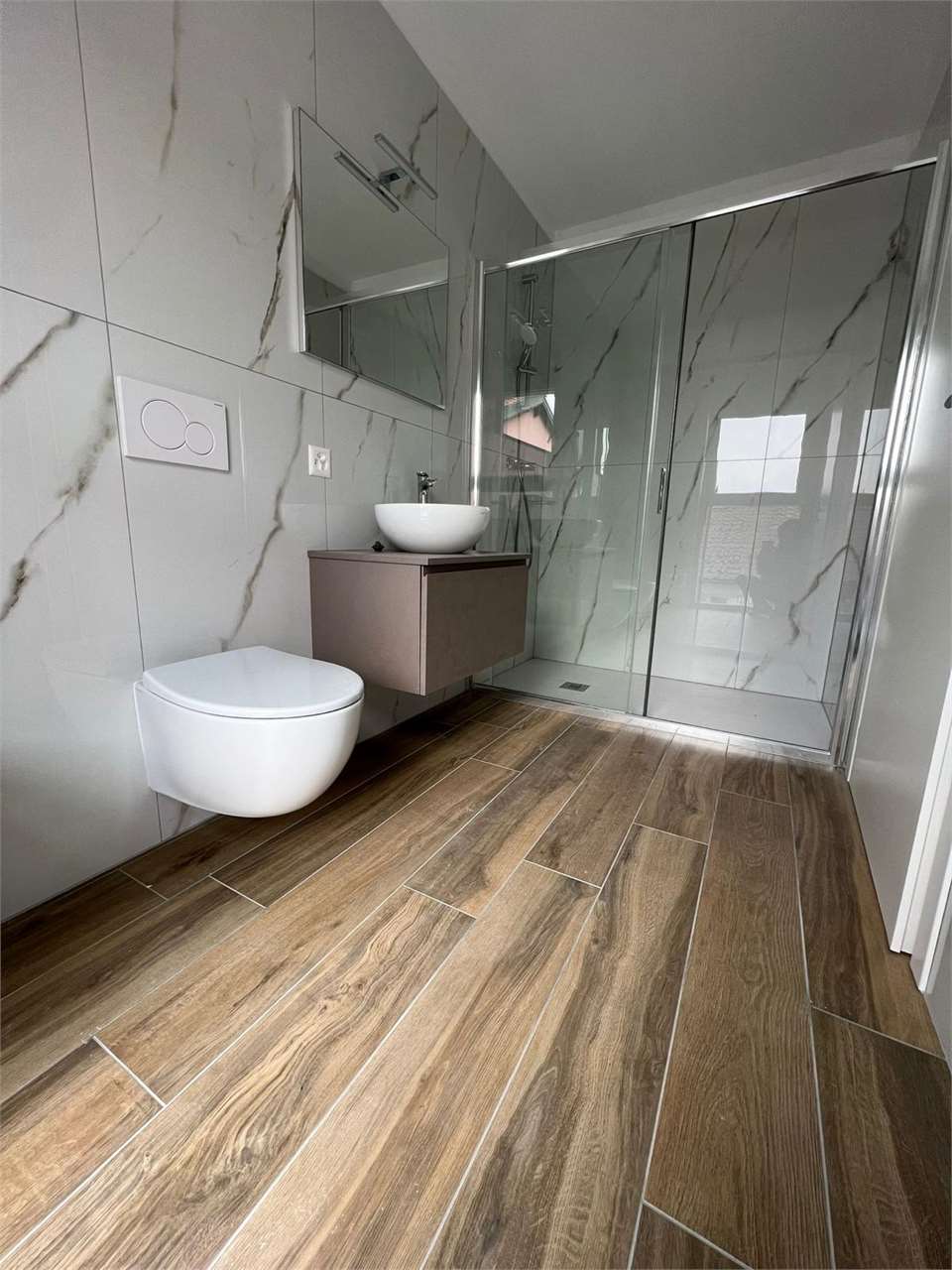 Modernes Bad mit Dusche und wandhängendem WC