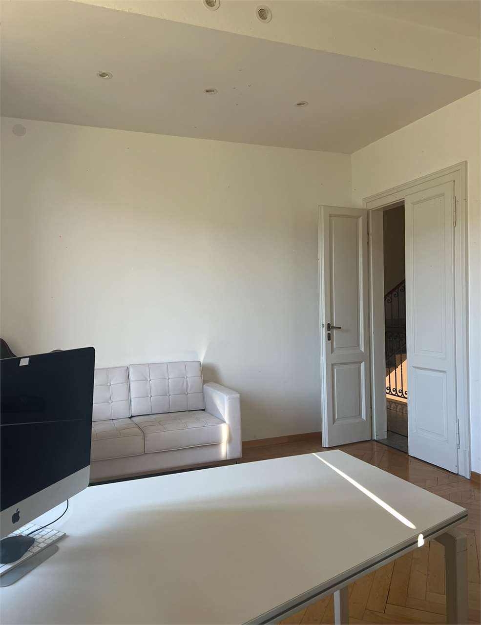 Helles, schlichtes Arbeits- bzw. Wohnzimmer mit offener Tür