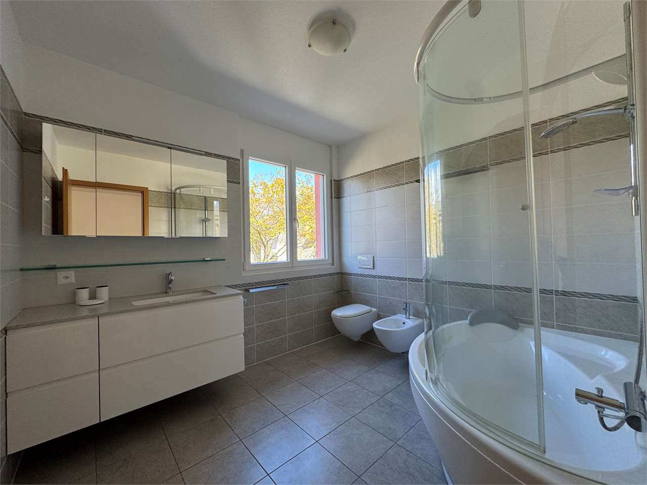 Modernes Badezimmer mit Badewanne, Dusche und Doppelwaschtisch