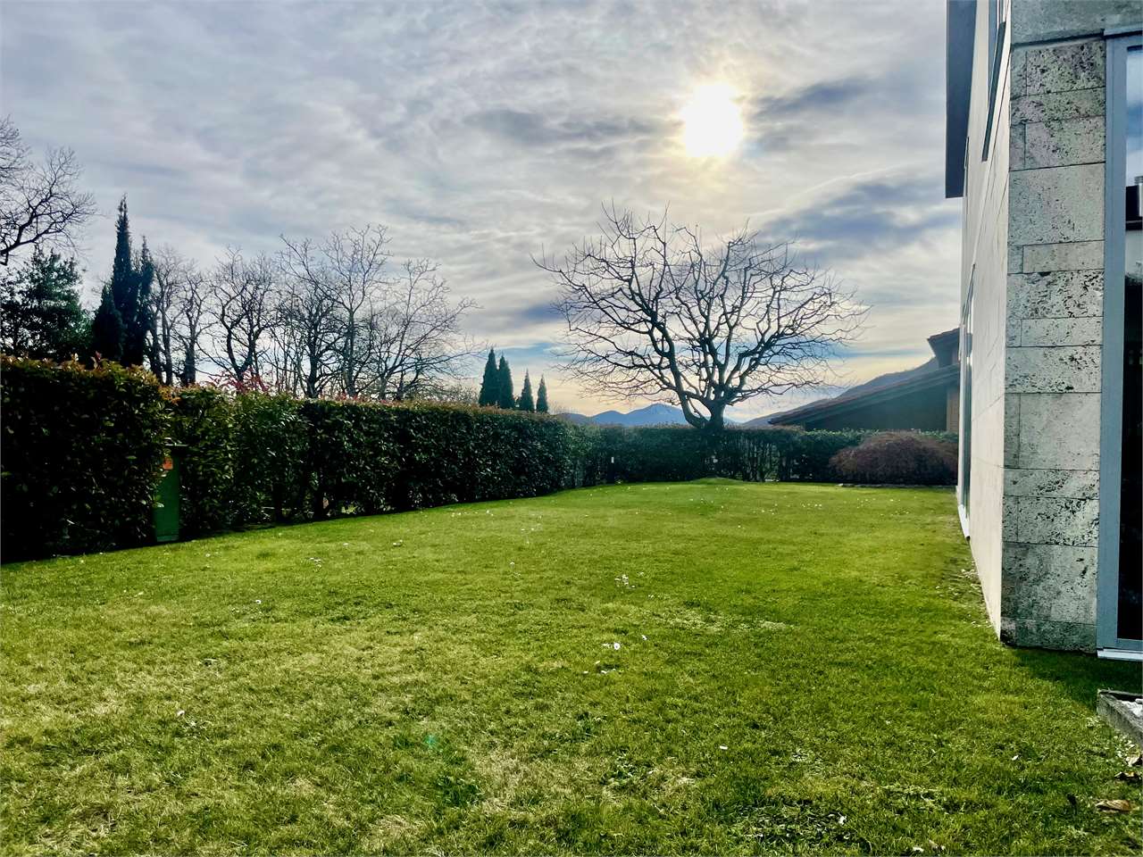 Gepflegter Garten mit Rasen und Hausaußenansicht