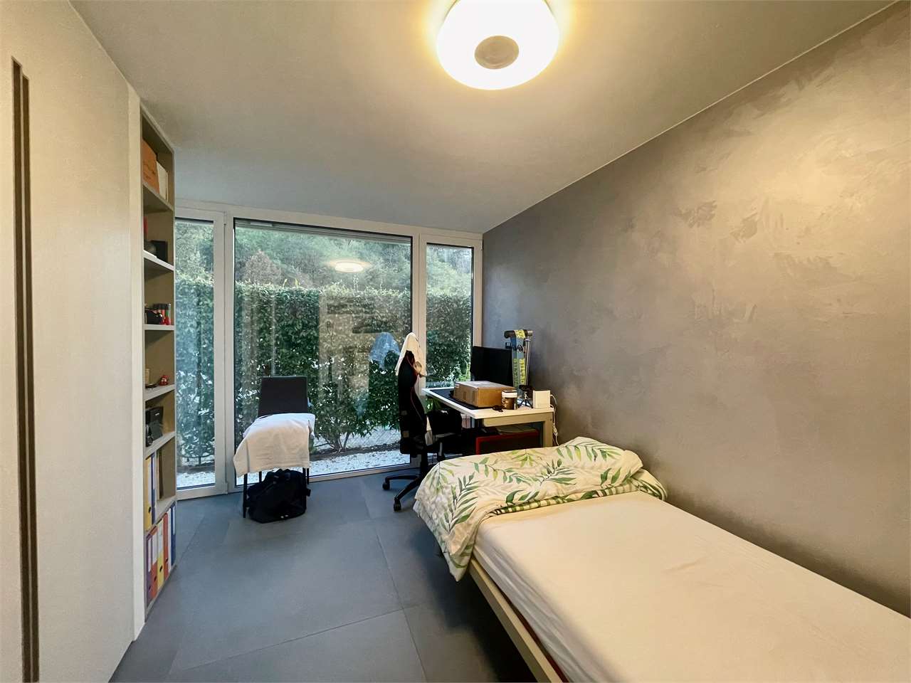 Schmales Schlafzimmer mit Arbeitsbereich und Gartenblick