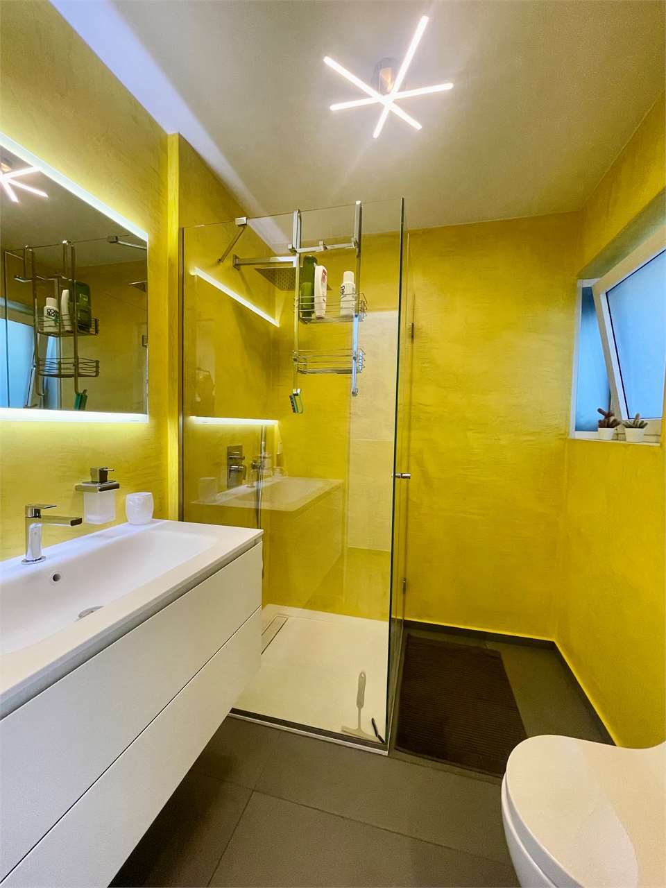 Modernes gelbes Badezimmer mit Glasdusche