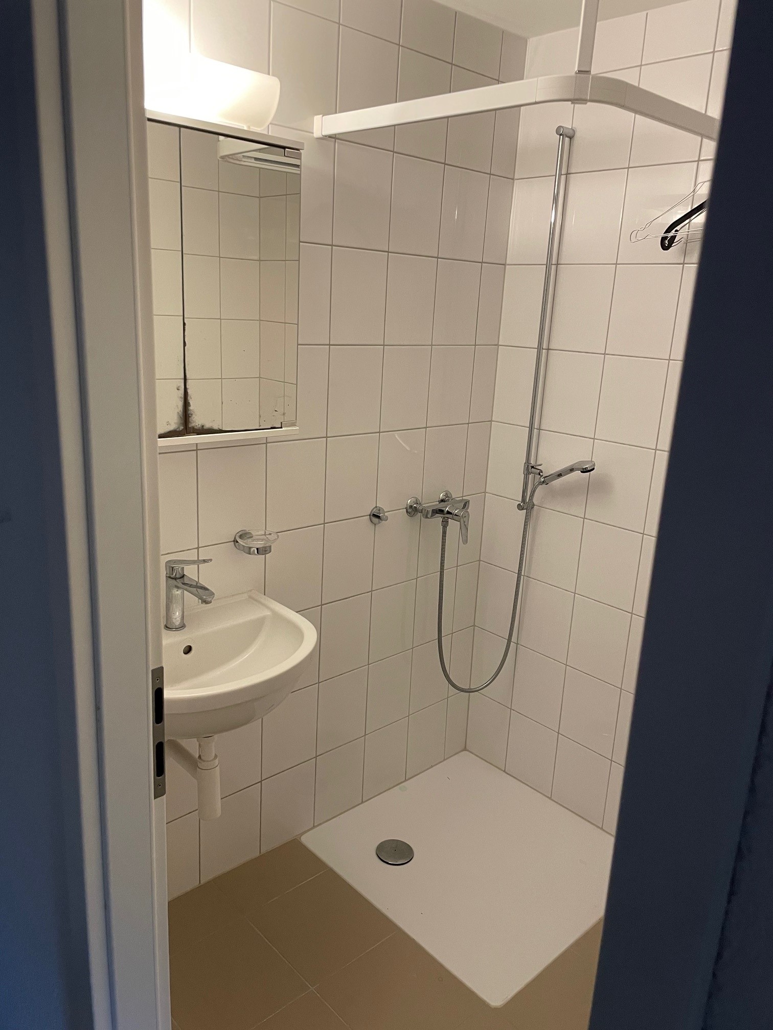 Kleine geflieste Dusche mit Waschbecken