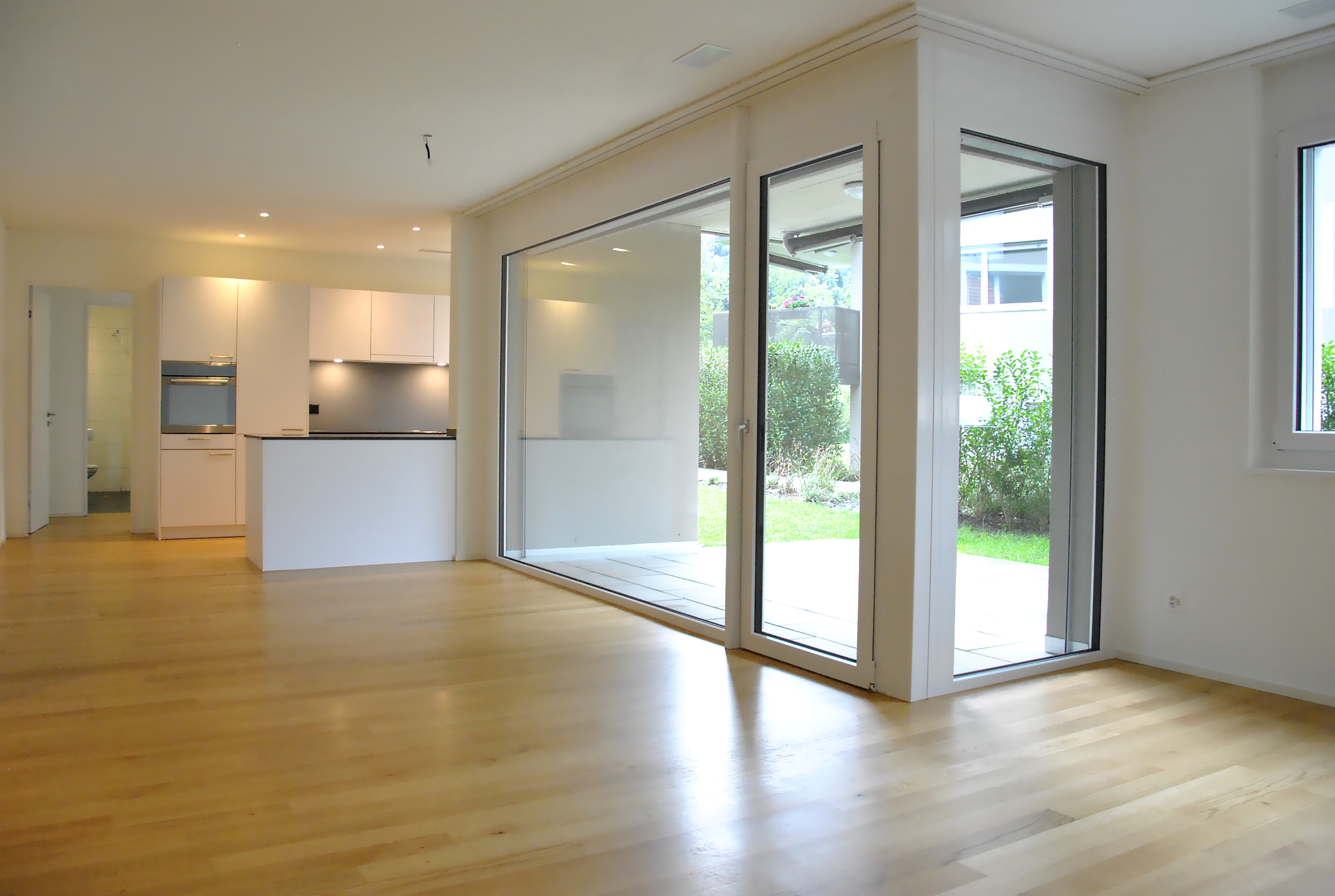 Offener Wohnbereich mit Küche und großer Glasfront