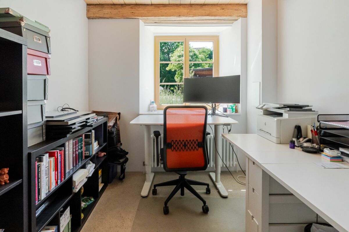 Arbeitszimmer mit Schreibtisch und Regal