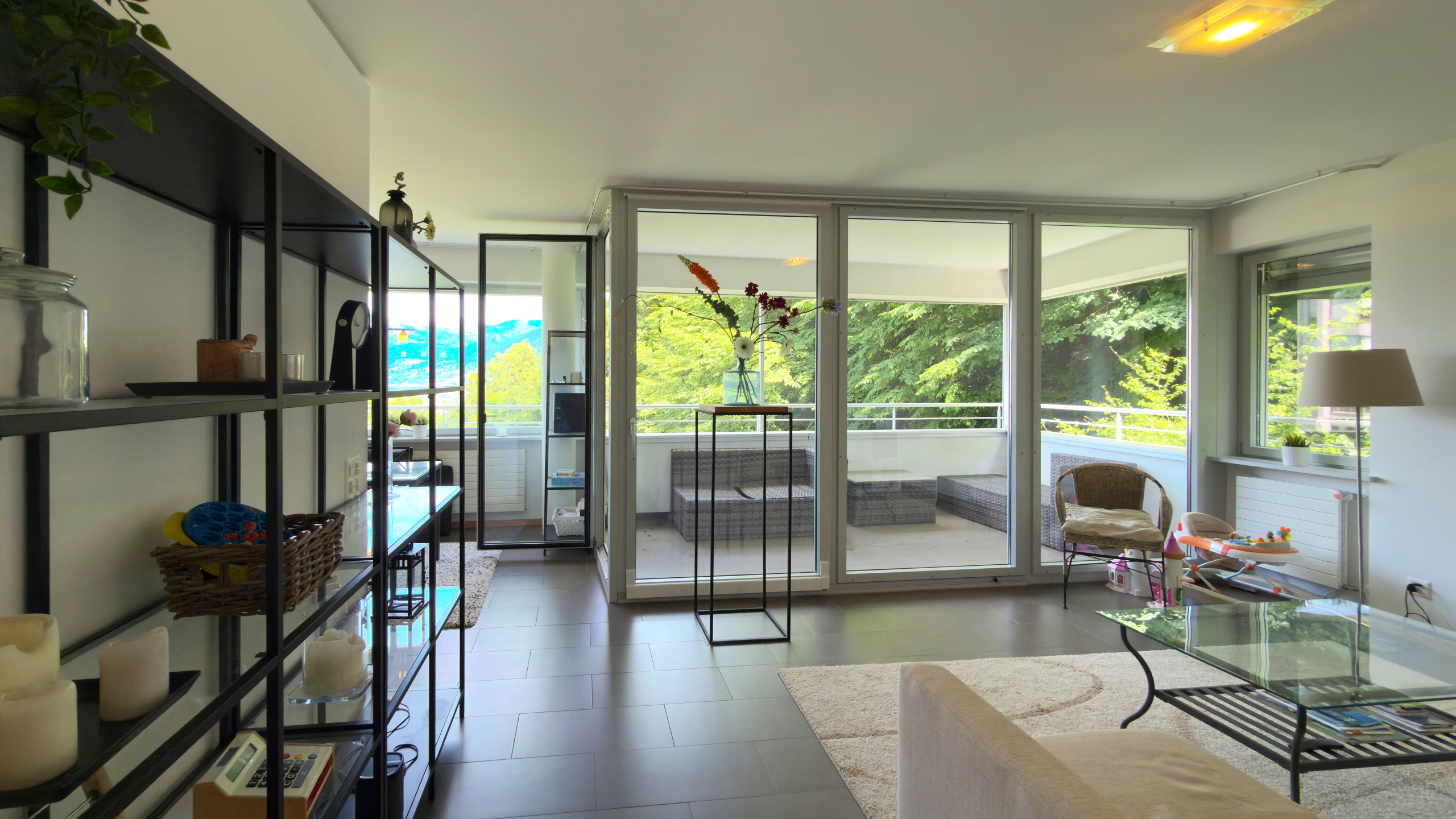 Wohnzimmer mit Balkon und großflächiger Verglasung