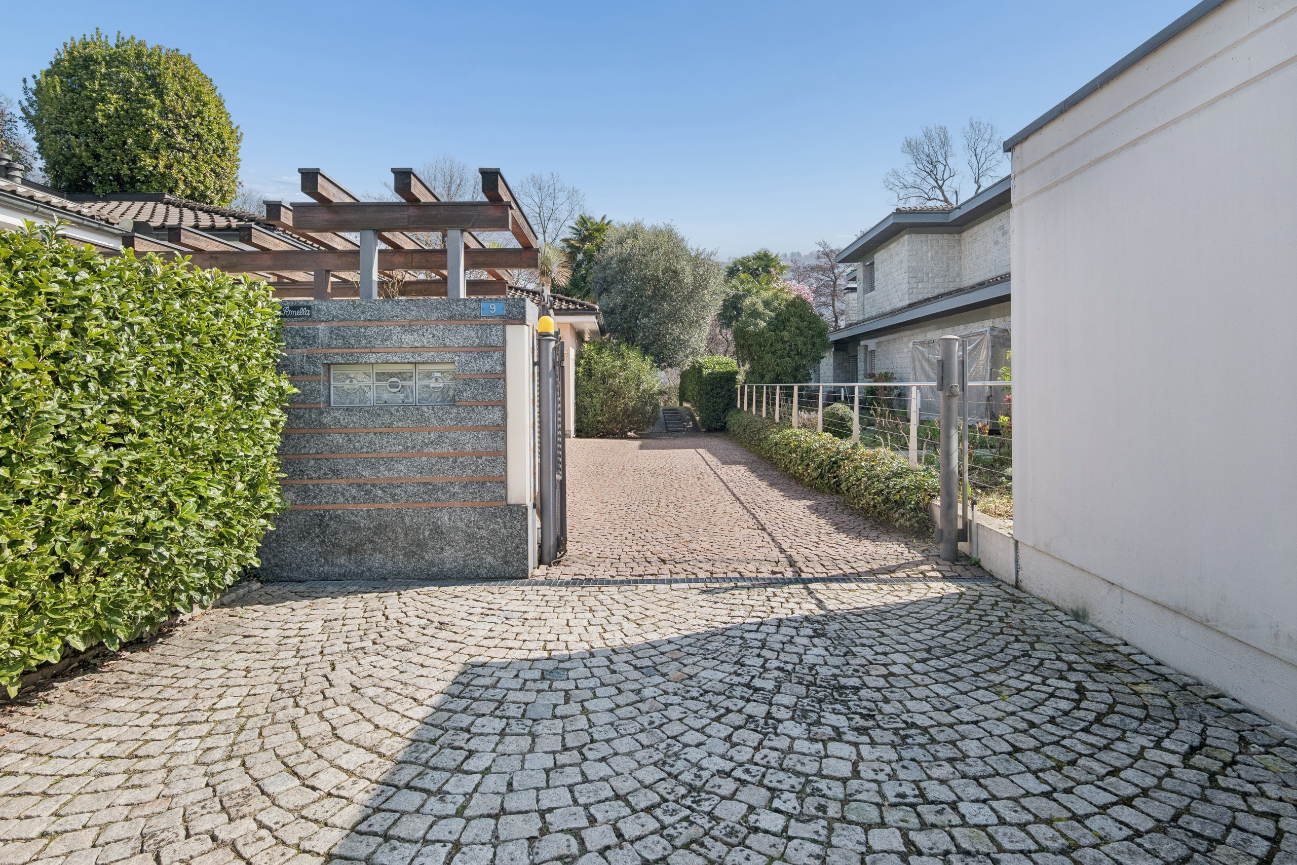 Einfahrt mit gepflastertem Vorhof und Gartenweg