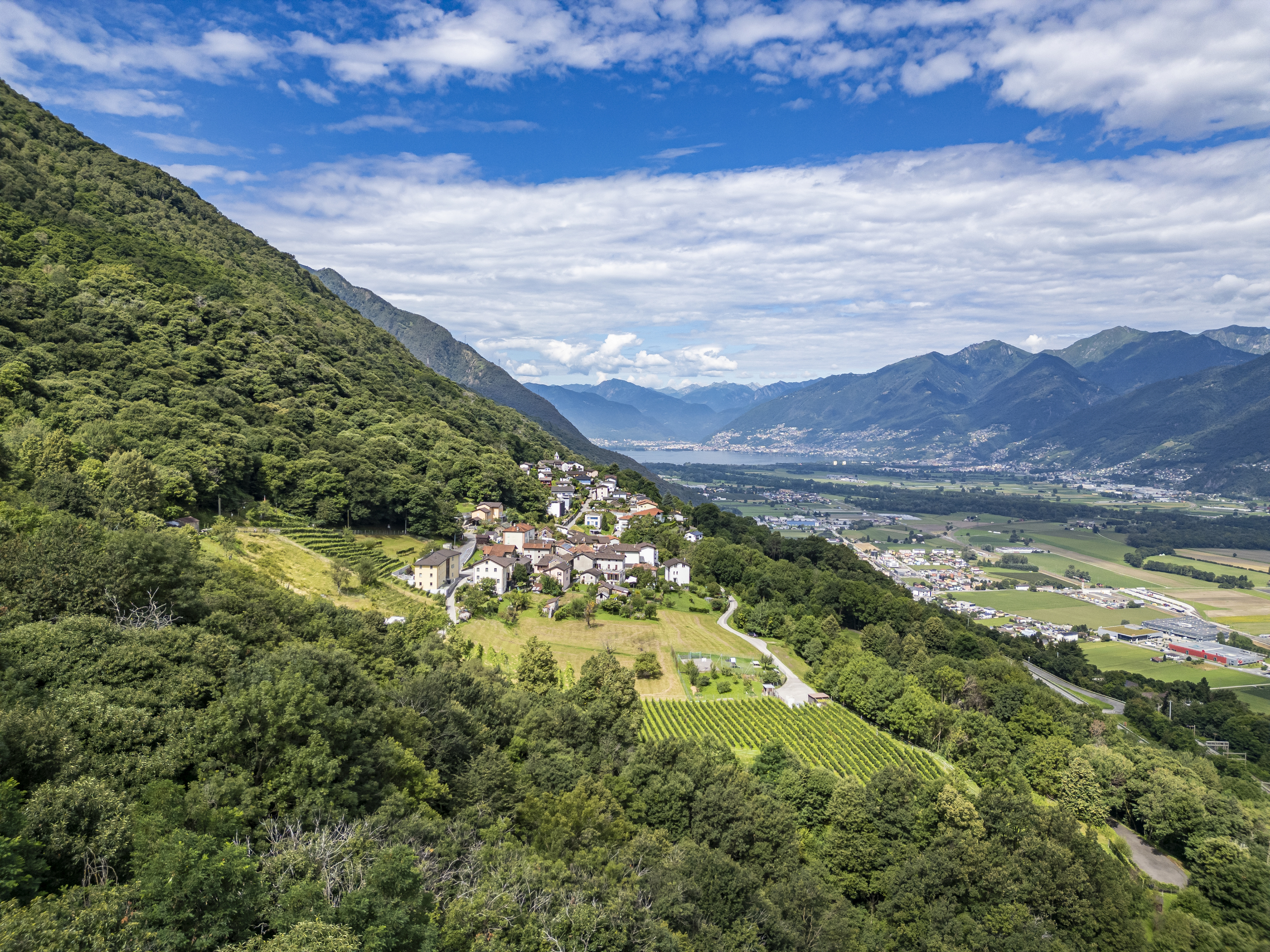 Landschaftsaufnahme mit Tal, Bergen und Siedlung