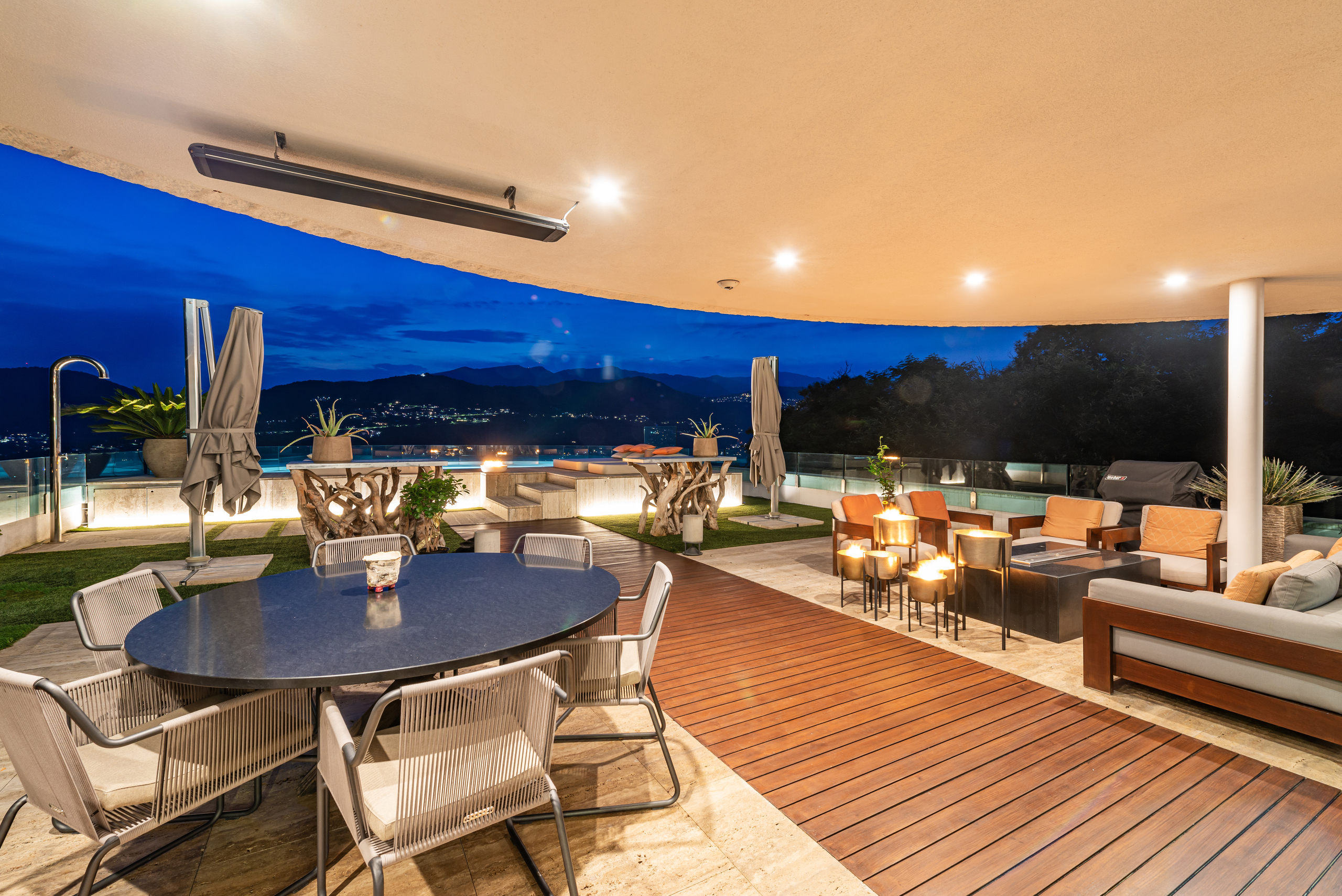 Luxuriöse Dachterrasse mit Lounge und Essbereich bei Nacht