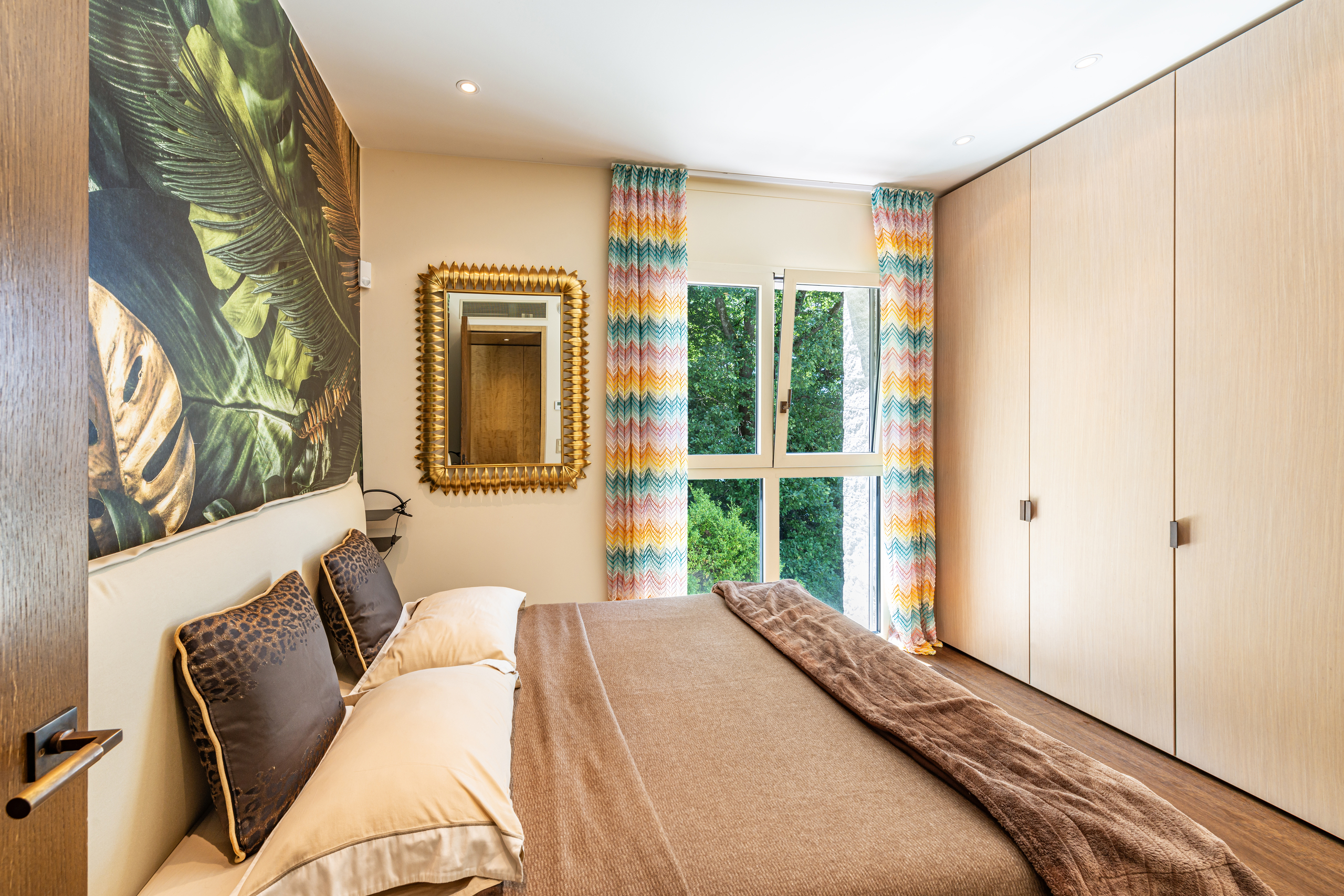 Schlafzimmer mit farbigen Vorhängen und großem Kleiderschrank