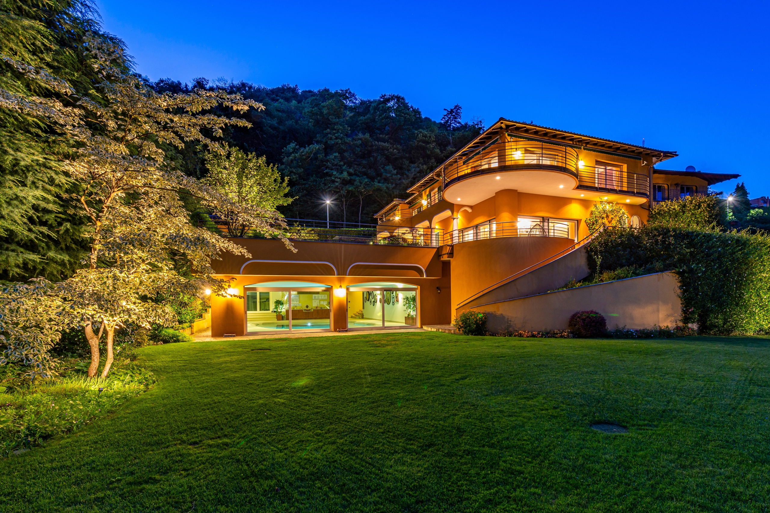Moderne Villa mit beleuchtetem Garten bei Nacht