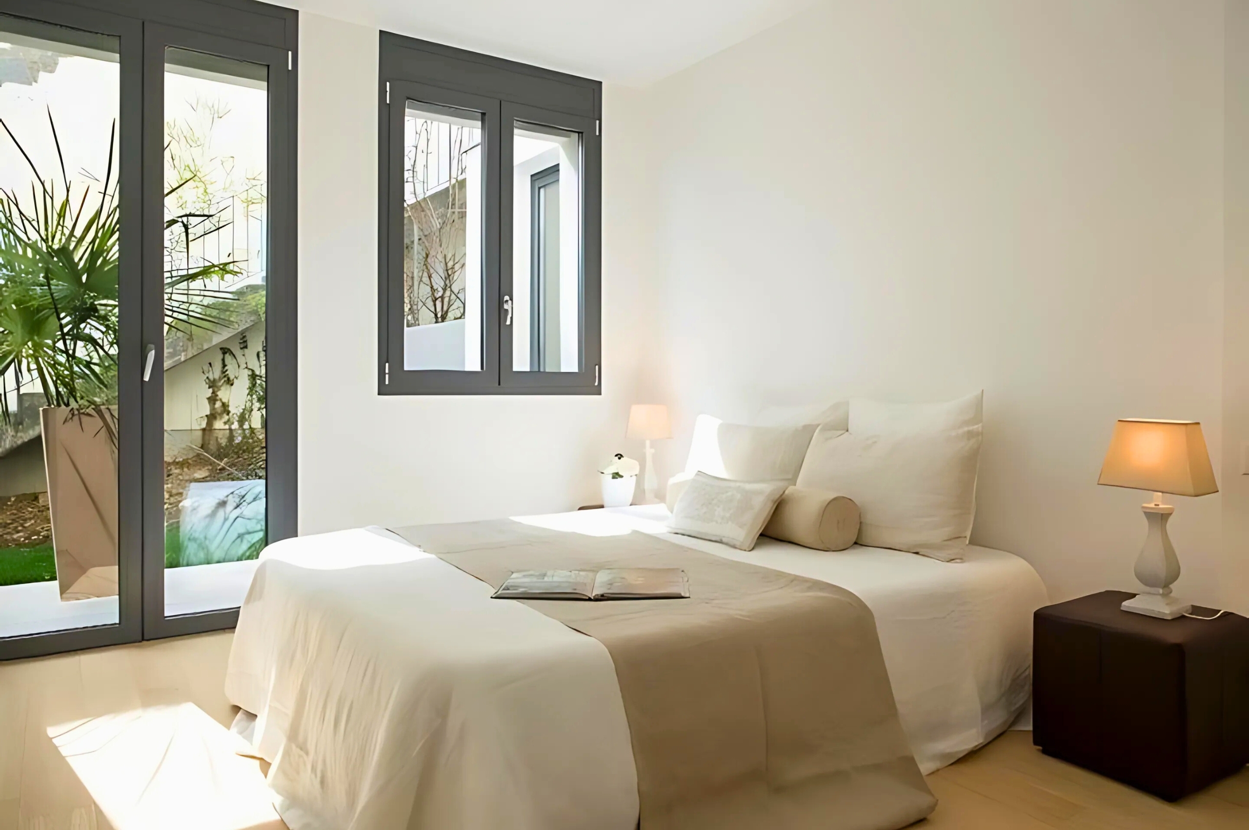 Helles Schlafzimmer mit zwei Betten und großen Fenstern