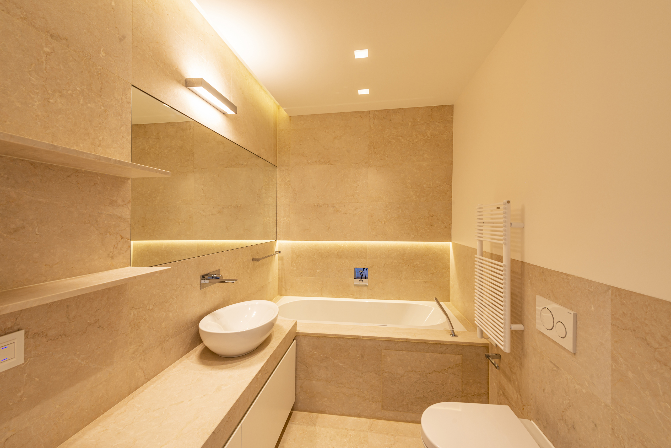 Luxuriöses Badezimmer mit Badewanne und Natursteinoberflächen