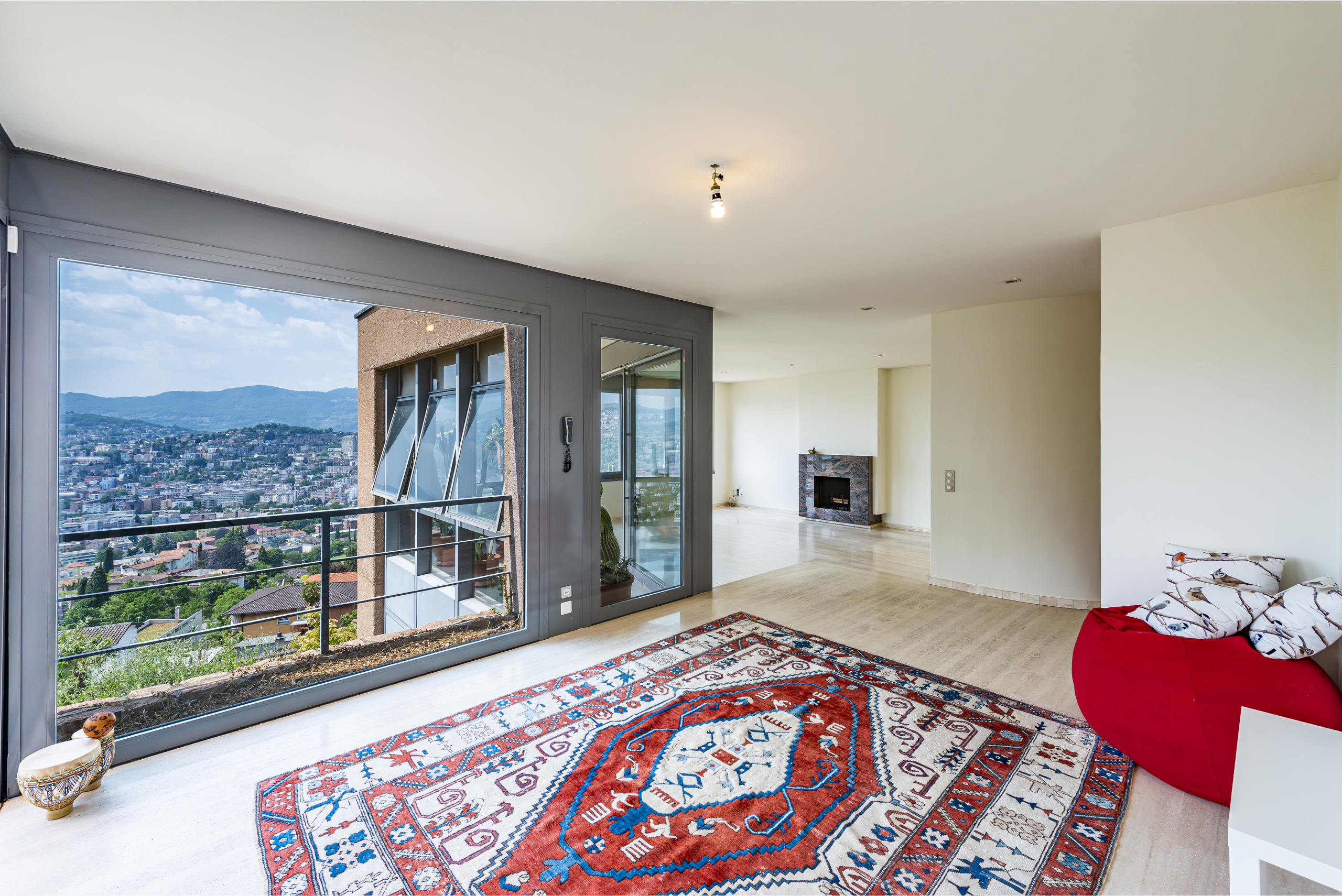 Heller Wohnraum mit Panoramafenster und Bergblick