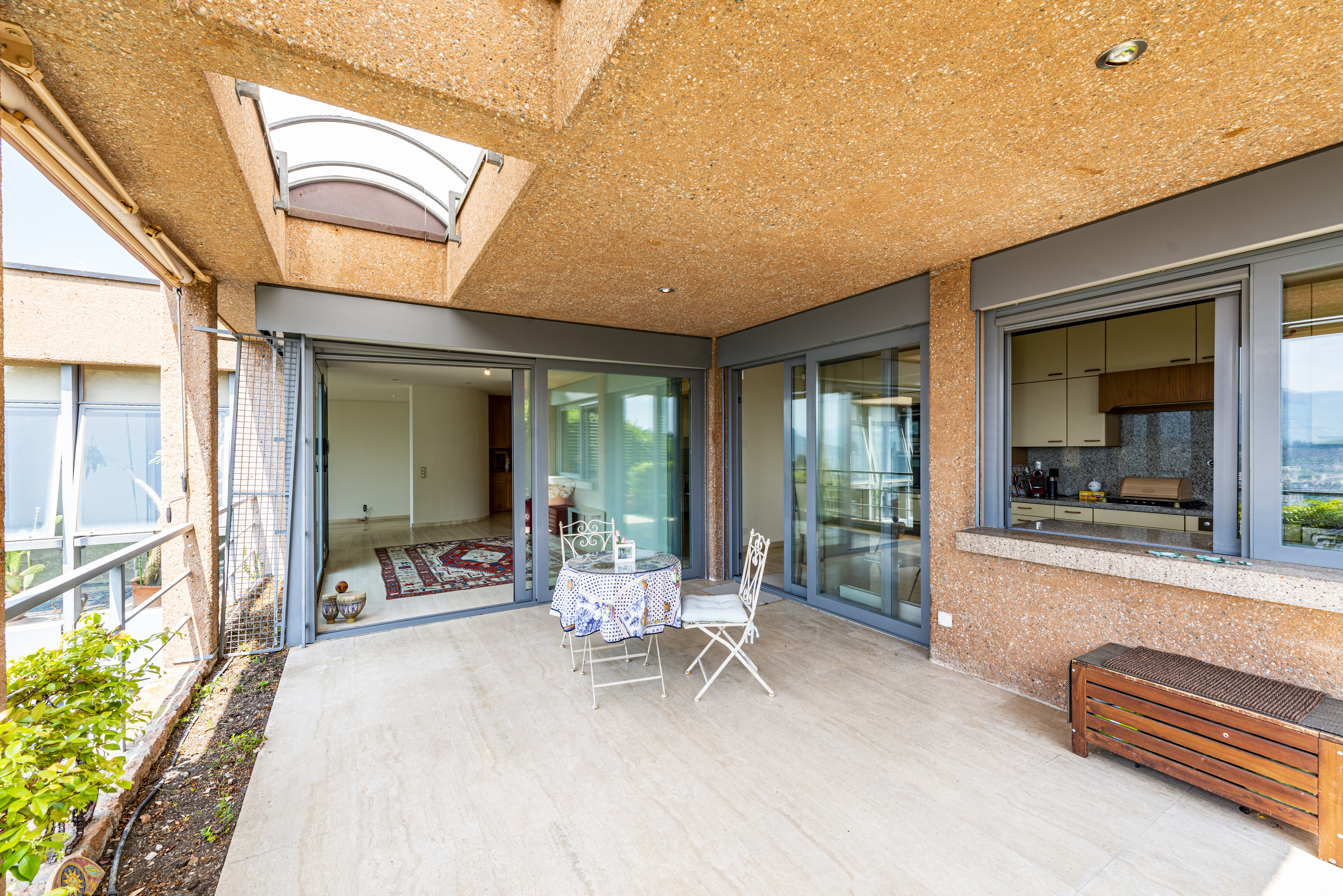 Überdachte Terrasse mit Blick in den Wohnbereich und zur Küche