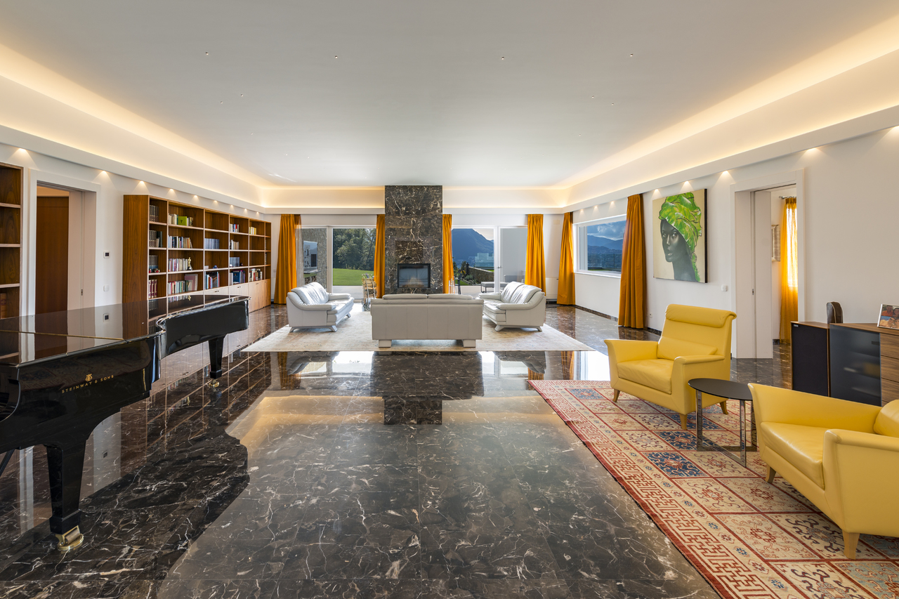 Großes, elegantes Wohnzimmer mit Klavier und Kamin