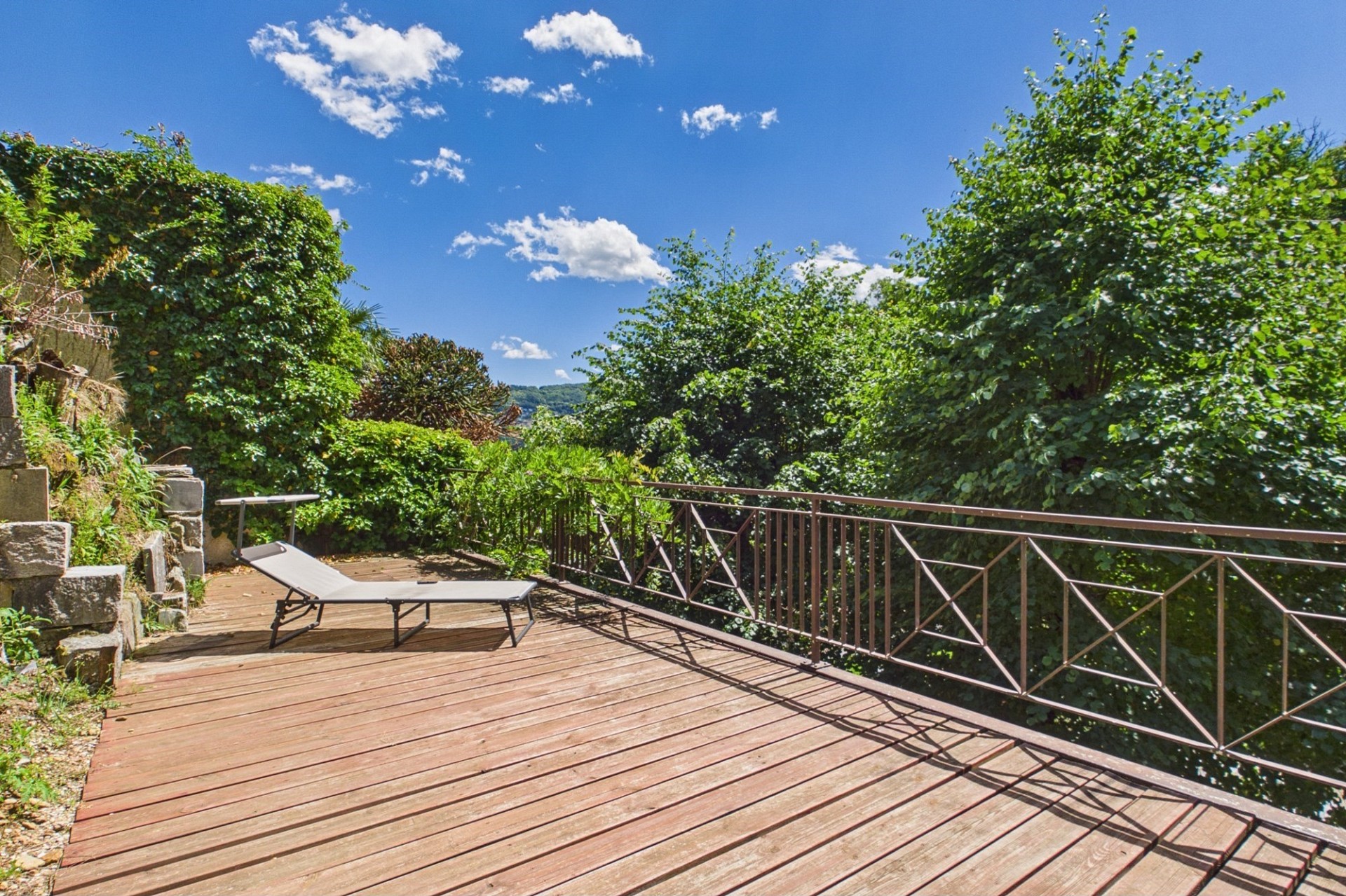 Terrasse mit Liege und Gartenblick