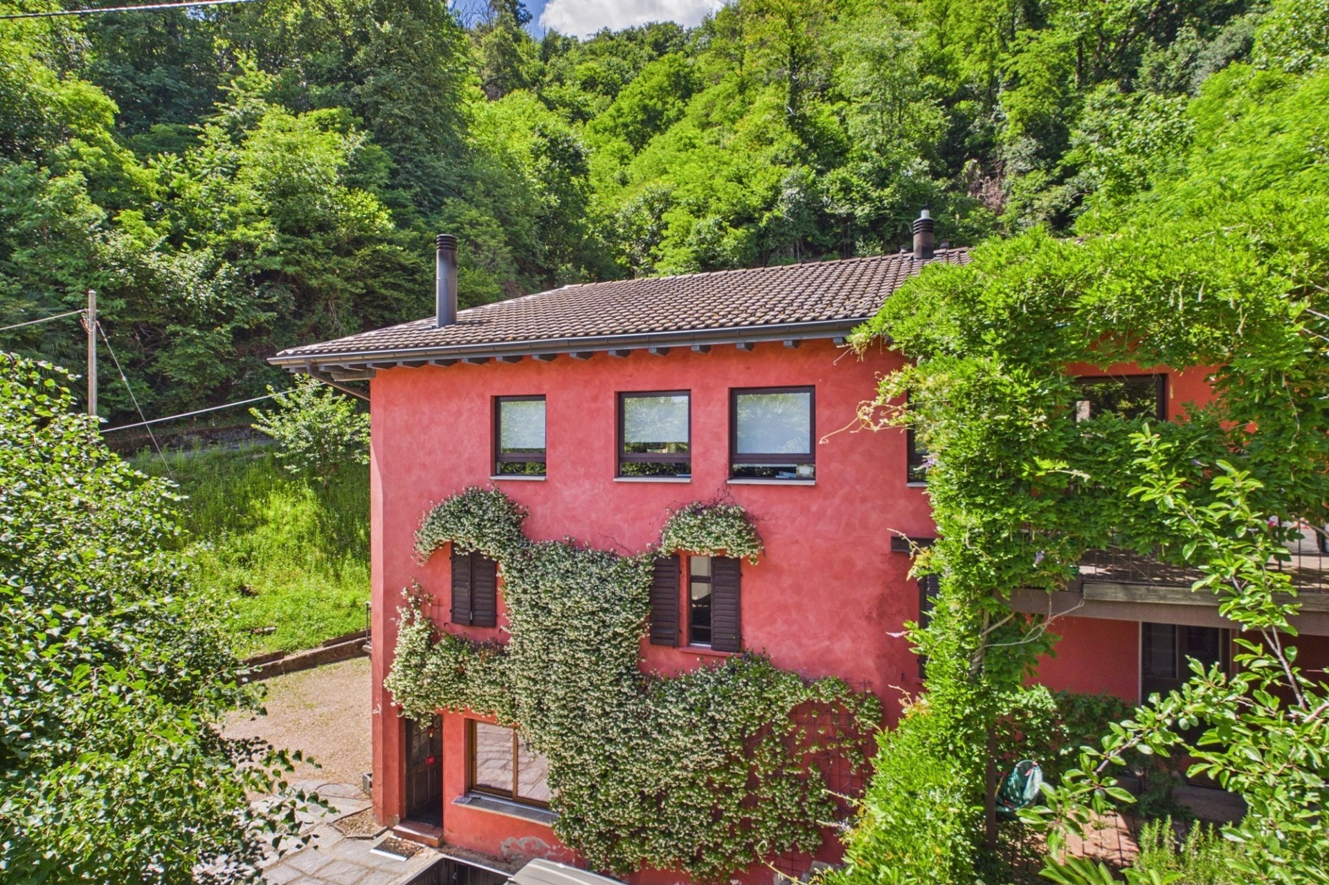 Rotes Haus in grüner Hanglage