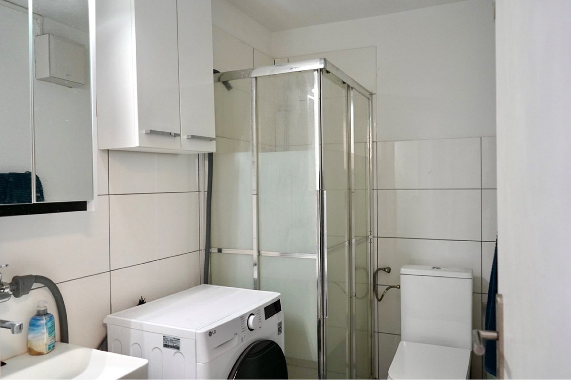 Modernes Badezimmer mit Duschkabine und Waschmaschine
