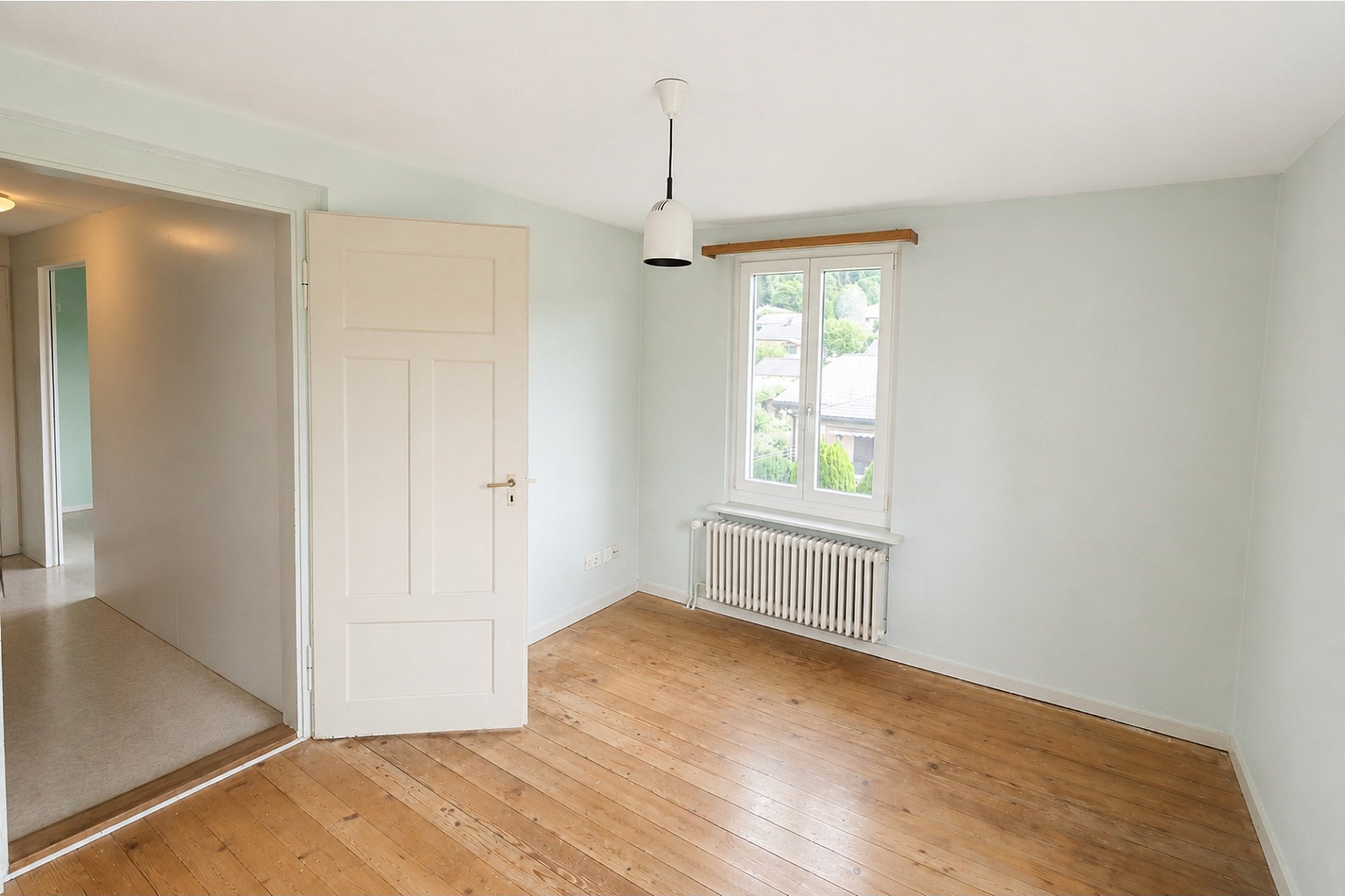 Helles, leer stehendes Zimmer mit Holzboden