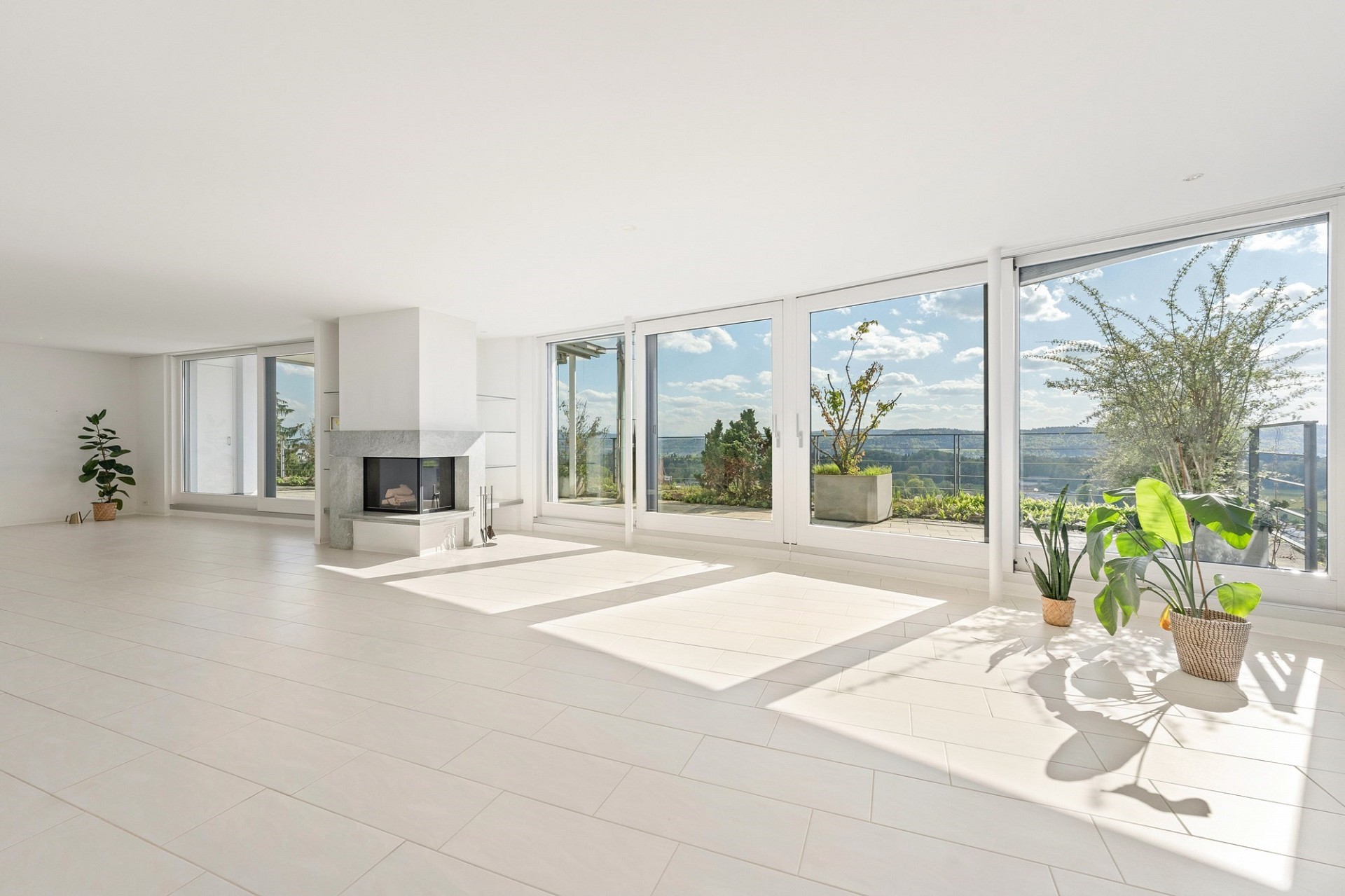 Heller Wohnraum mit Panoramafenstern und Kamin
