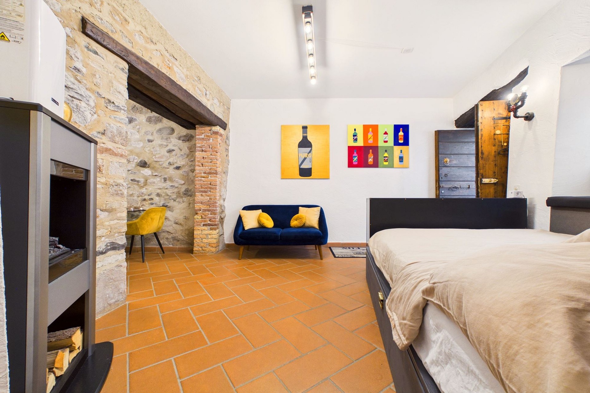 Rustikales Schlafzimmer mit Steinwand und Terrakottaboden