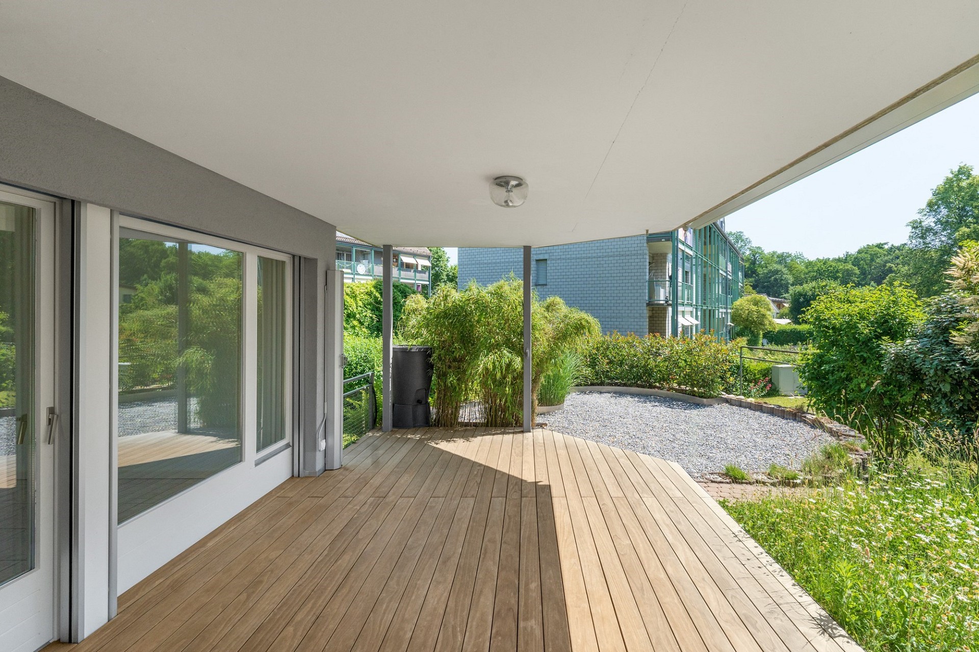 Überdachte Holzterrasse mit Gartenblick