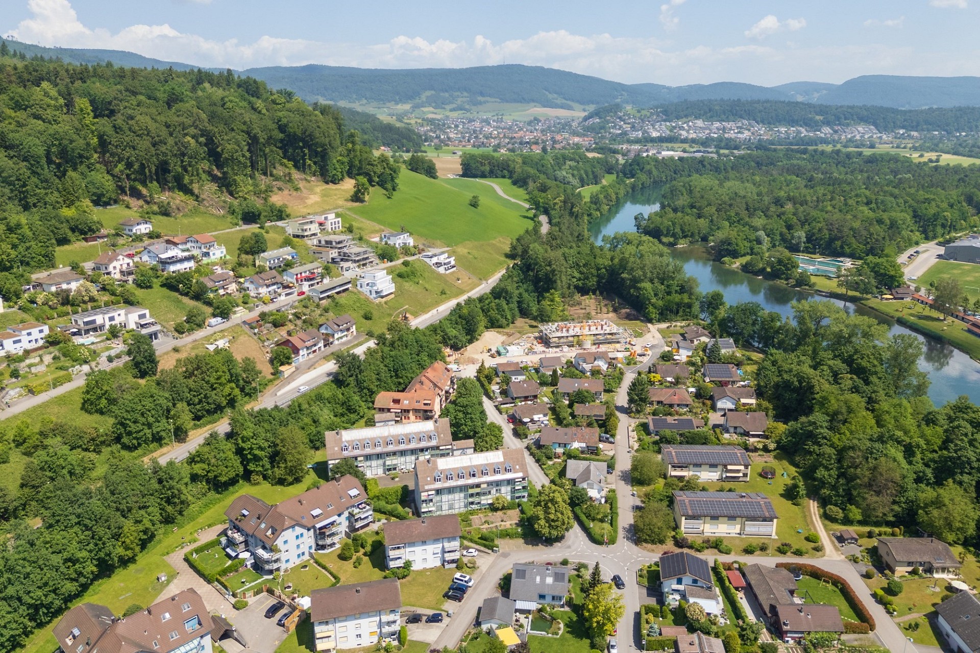 Luftaufnahme eines grünen Wohngebiets am Fluss