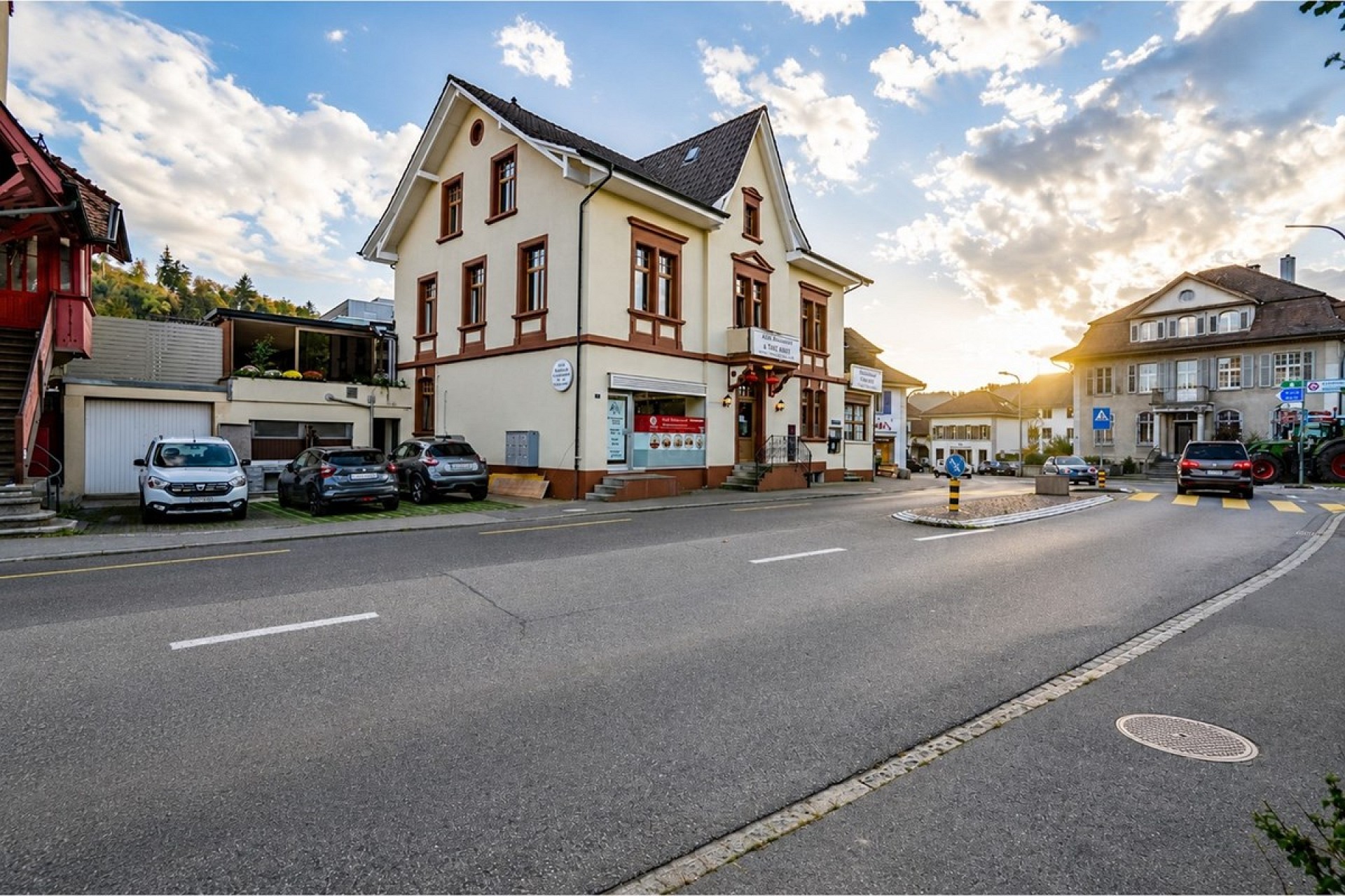 Straßenansicht eines Gebäudes mit Giebel und Nachbarhäusern