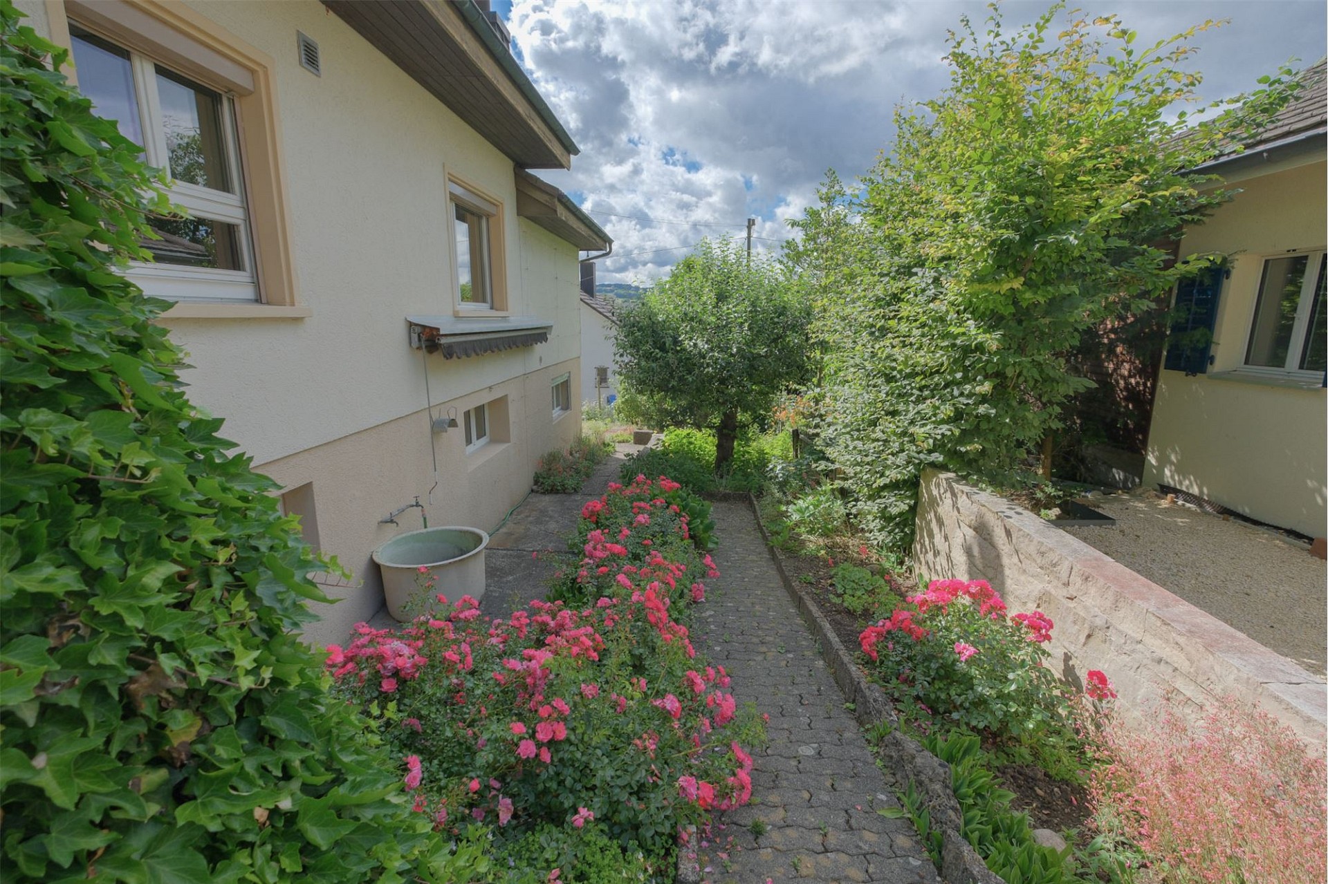 Gepflegter Gartenweg zwischen Wohnhäusern