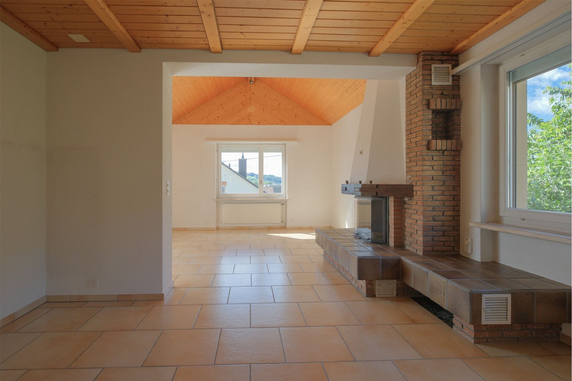 Heller Wohnraum mit Kamin und Holzdecke