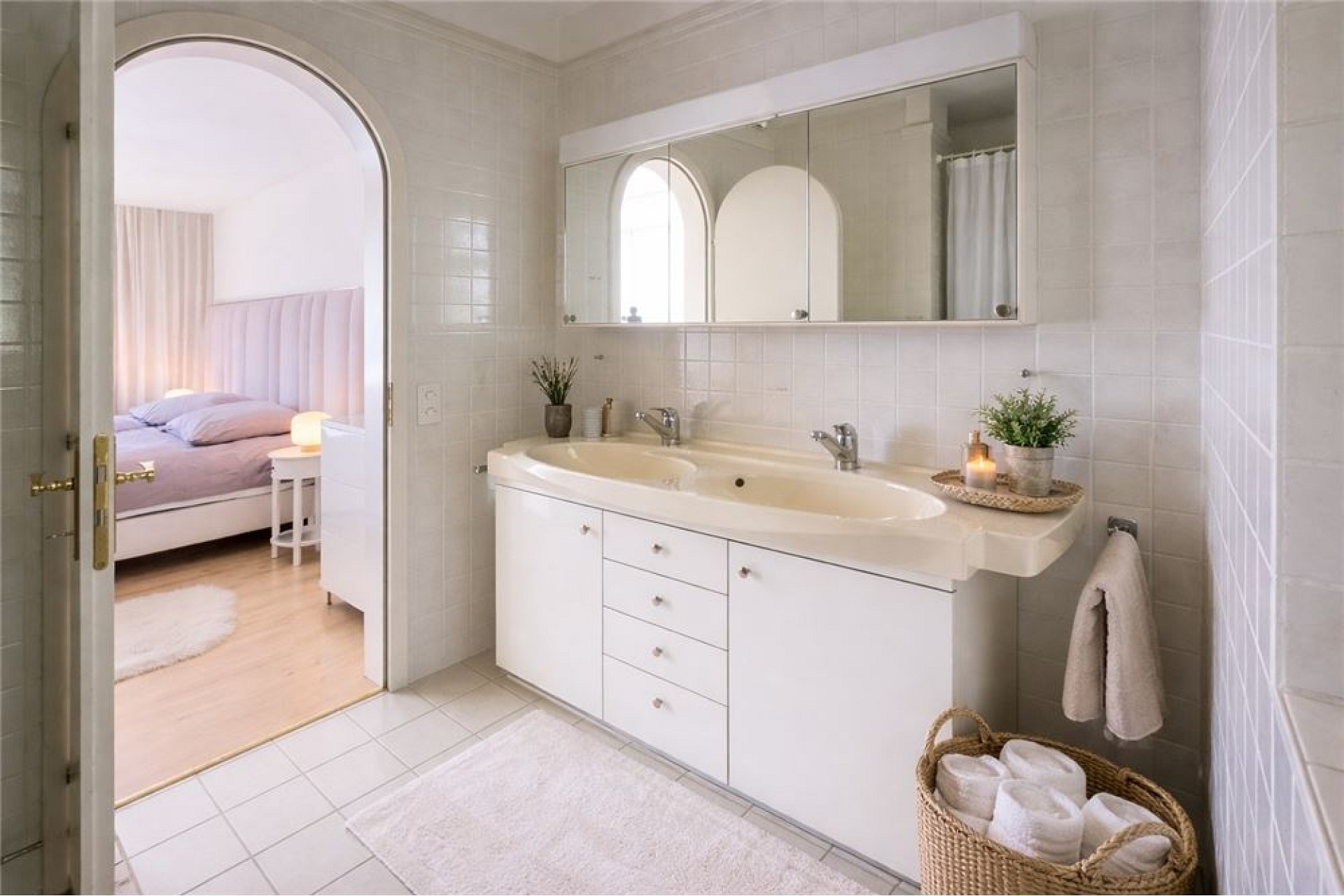 Helles Badezimmer mit Blick ins Schlafzimmer