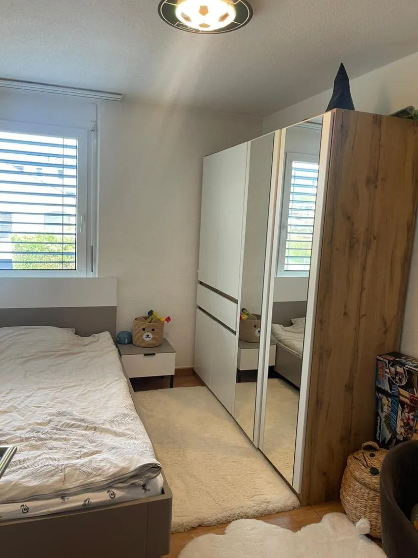Kleines Schlafzimmer mit Fenster und Kleiderschrank