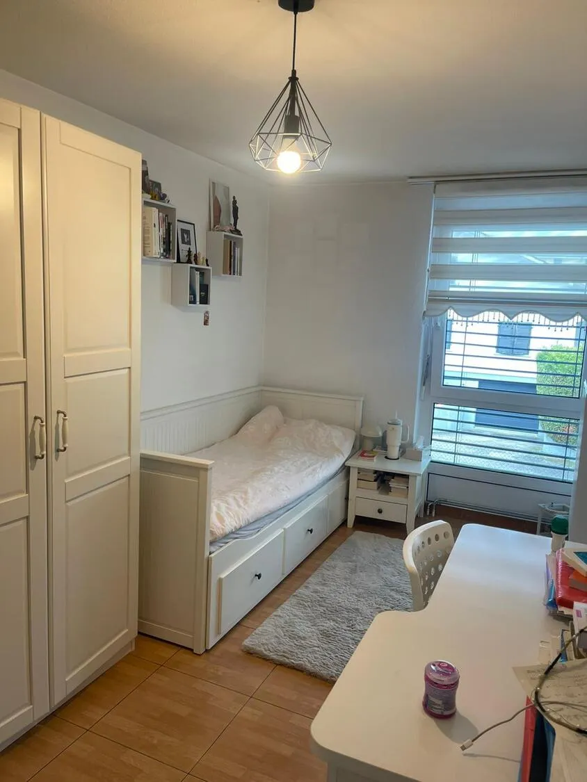 Kleines, helles Schlafzimmer mit Bett und Schrank