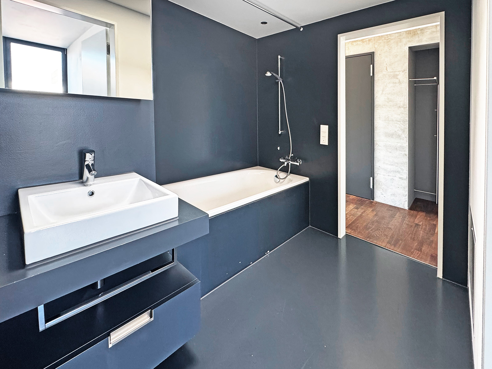 Modernes Badezimmer mit dunklen Wänden und Wanne