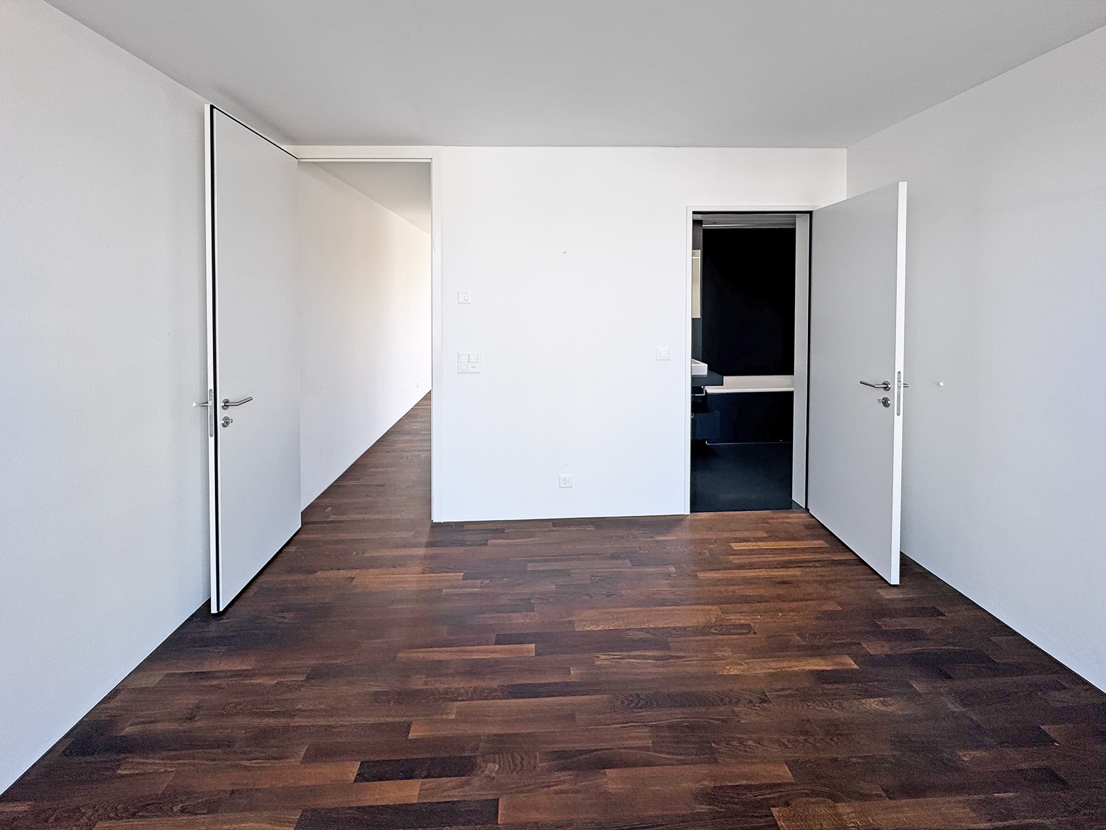 Modernes, leeres Zimmer mit zwei offenen Türen
