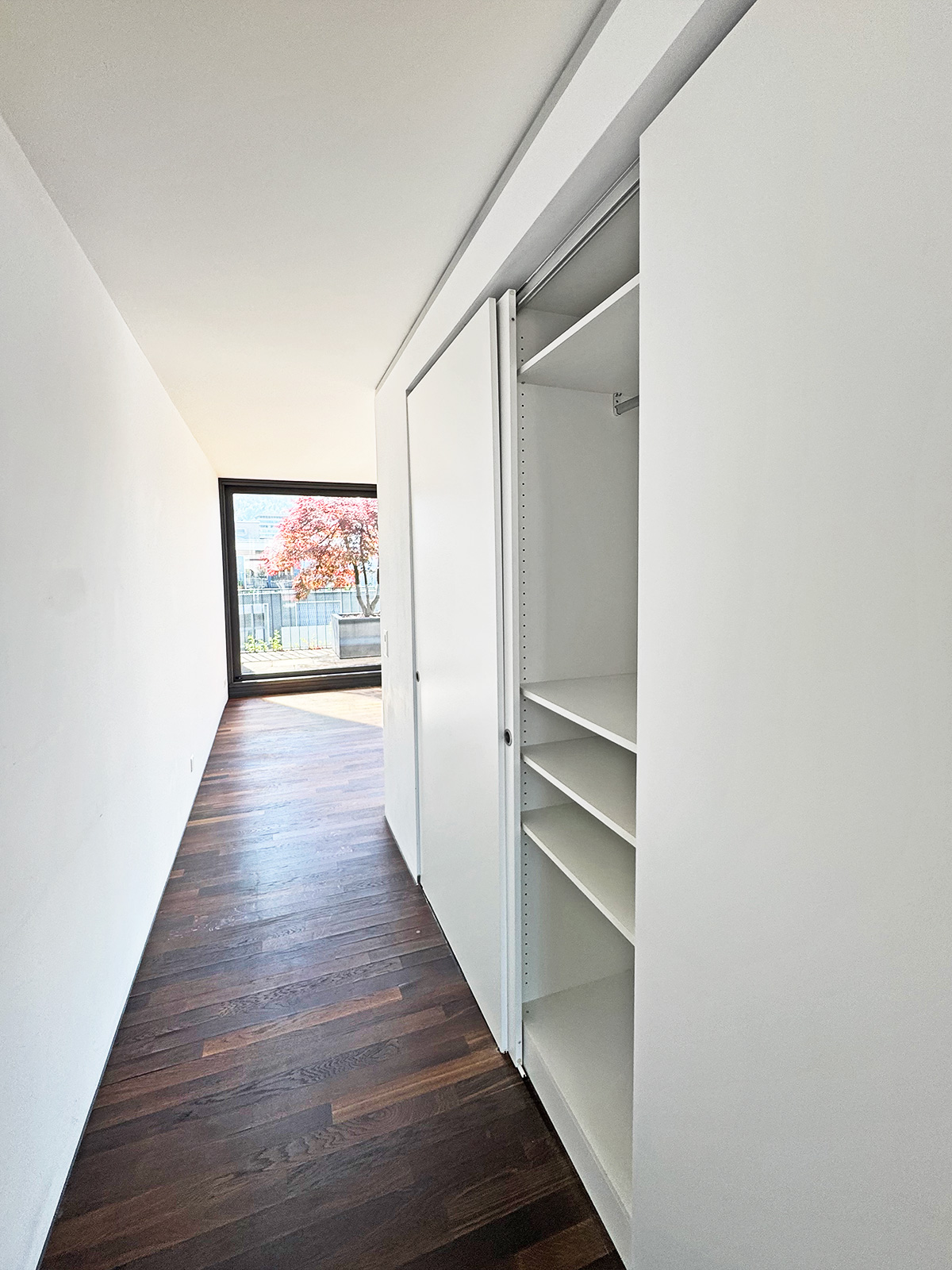 Heller Flur mit Einbauschrank und Blick ins Freie