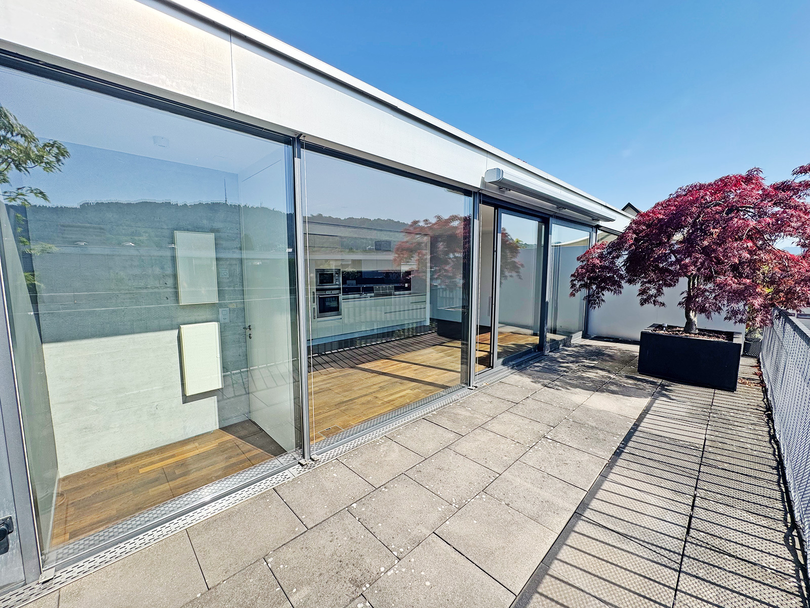 Dachterrasse mit Glasfront und Pflanzkübel