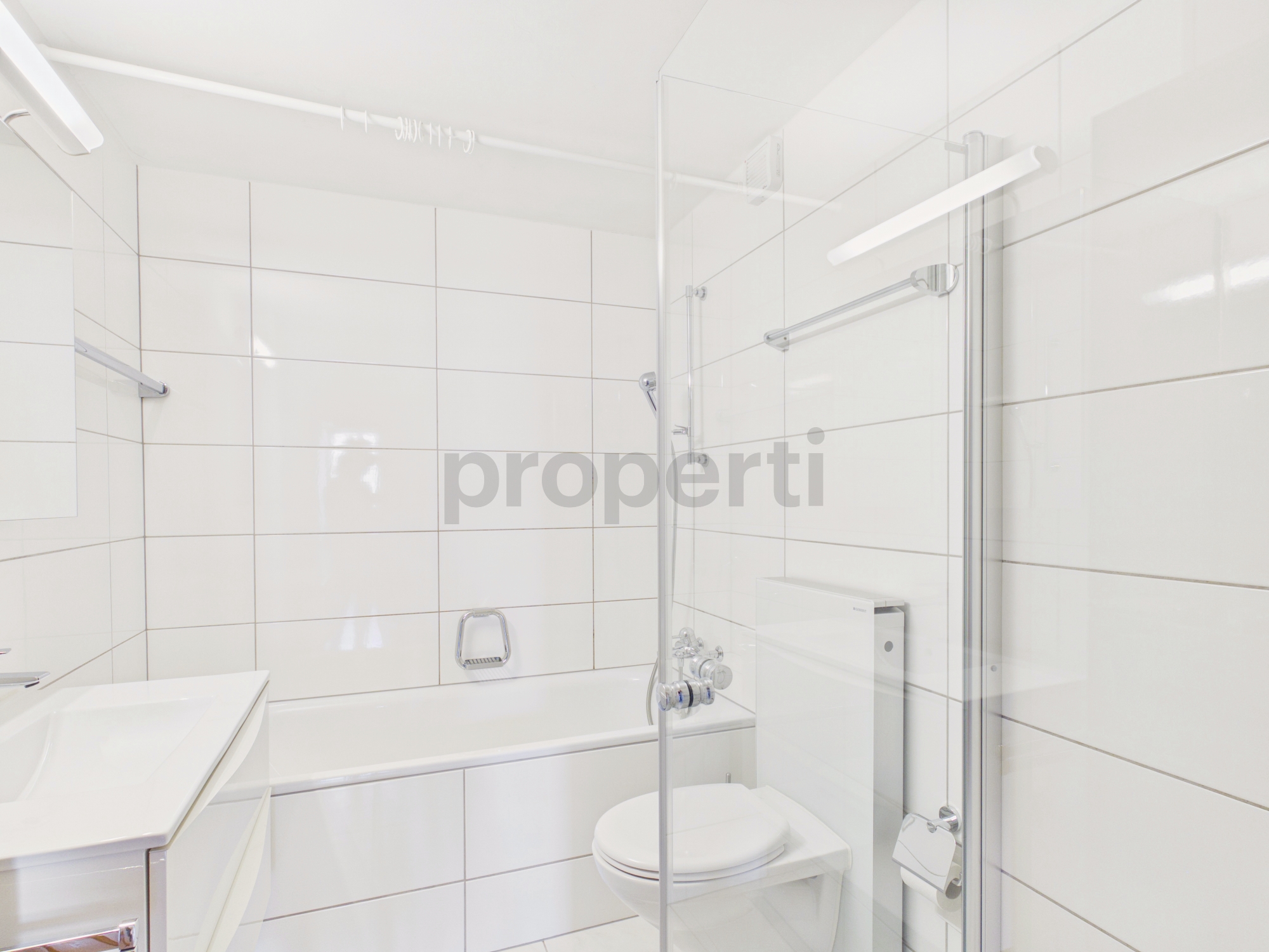 Helles, modernes Badezimmer mit Badewanne und Duschabtrennung
