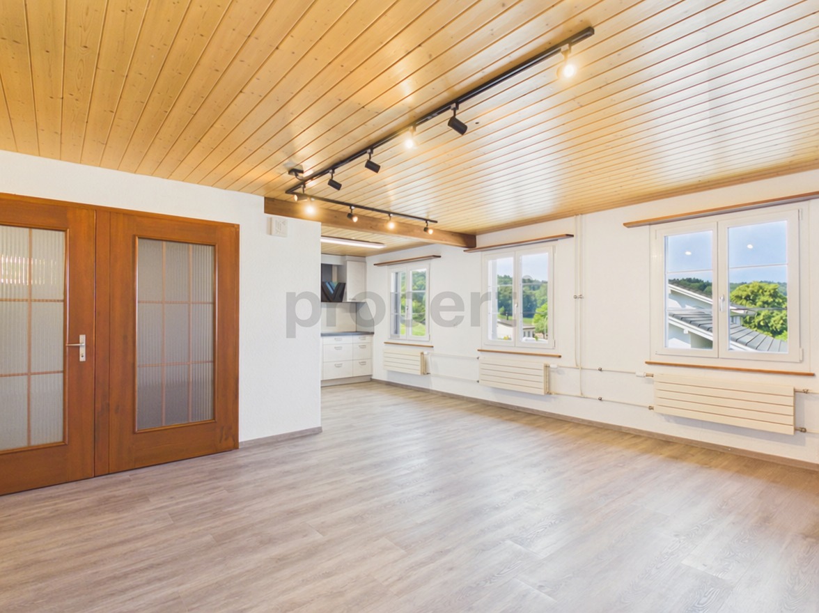 Heller Wohnraum mit Holzdecke und Blick ins Grüne