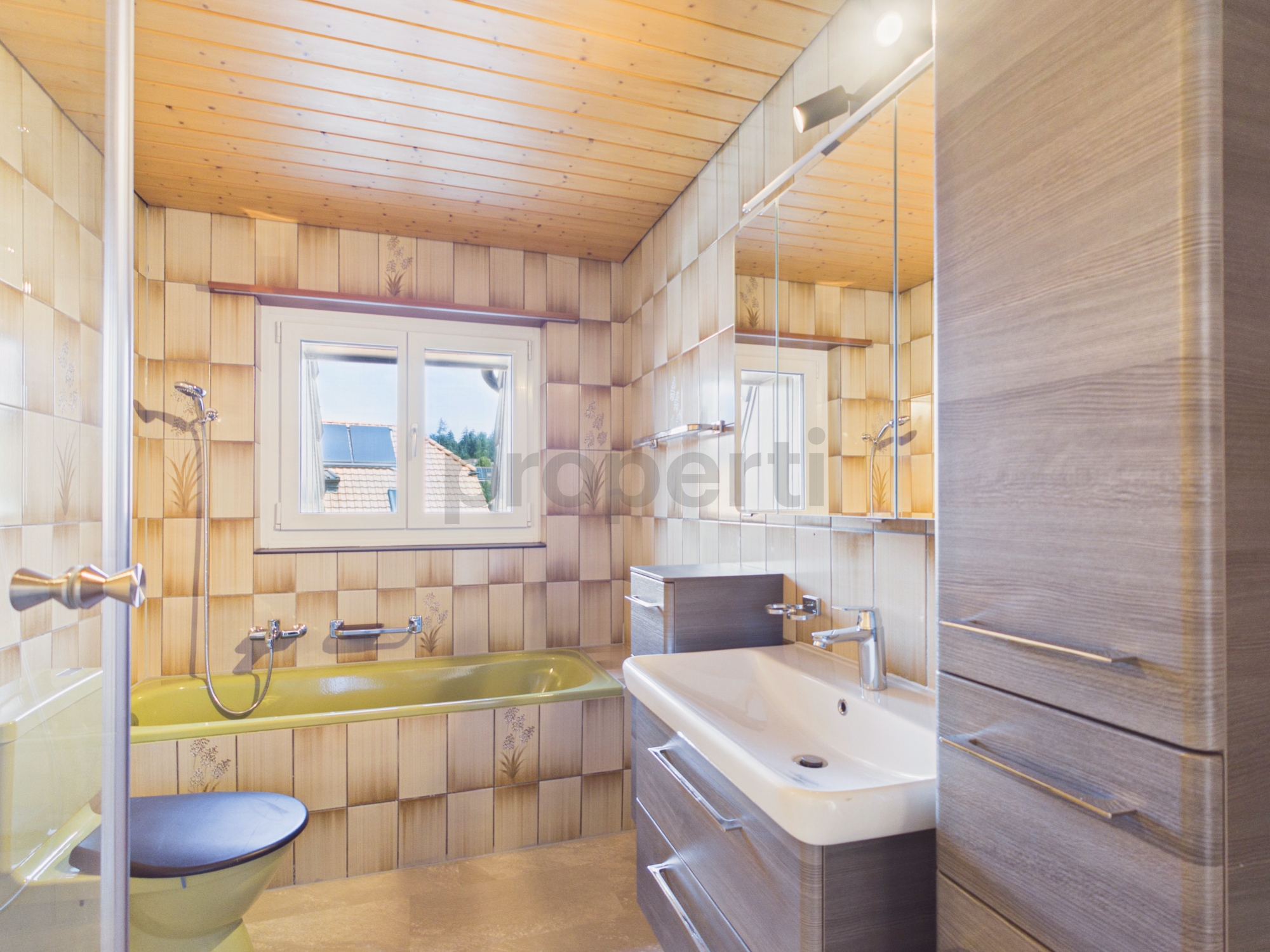 Badezimmer mit Holzverkleidung und Badewanne