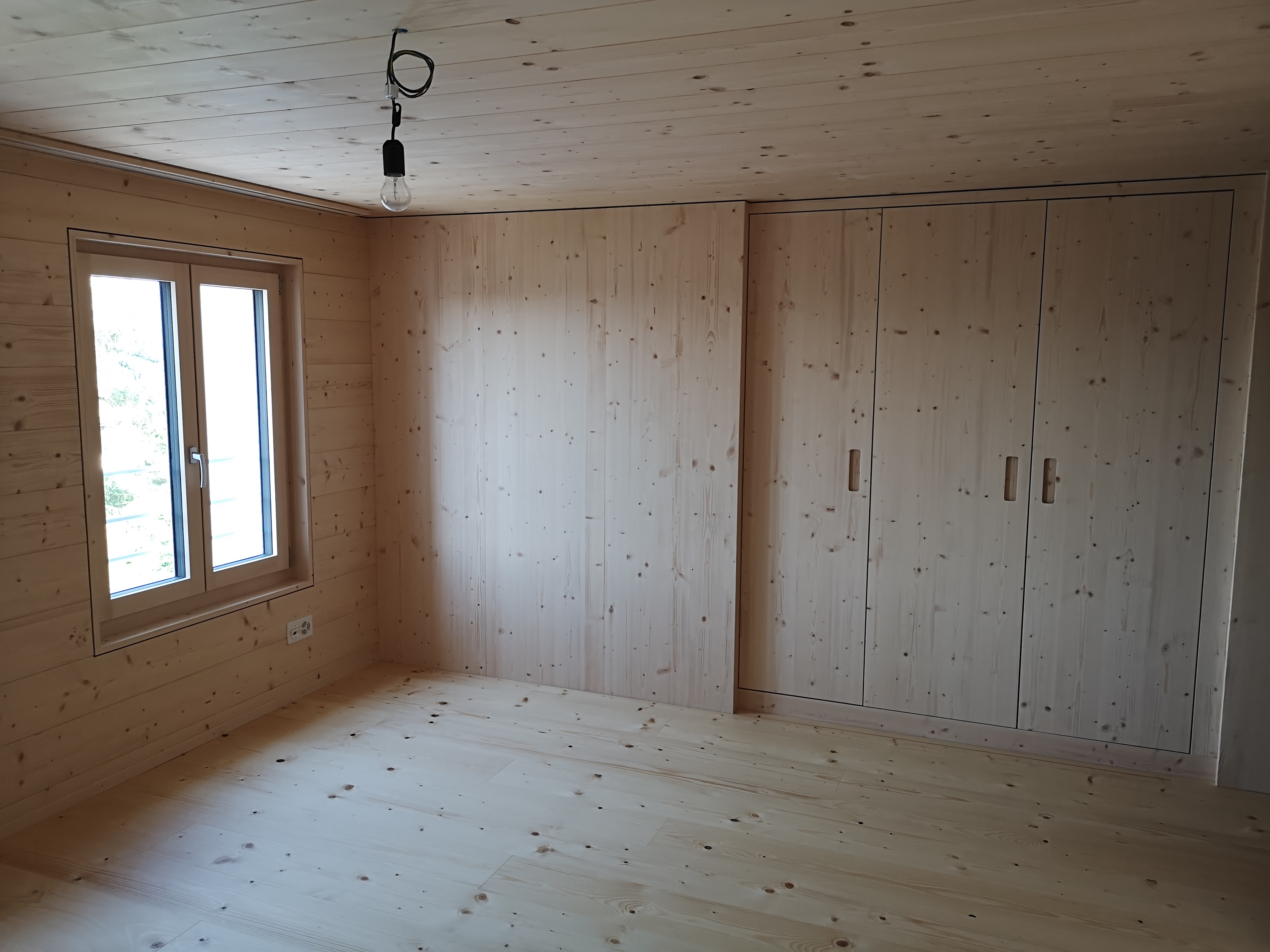 Helles, naturbelassenes Holz-Zimmer mit Einbauschrank