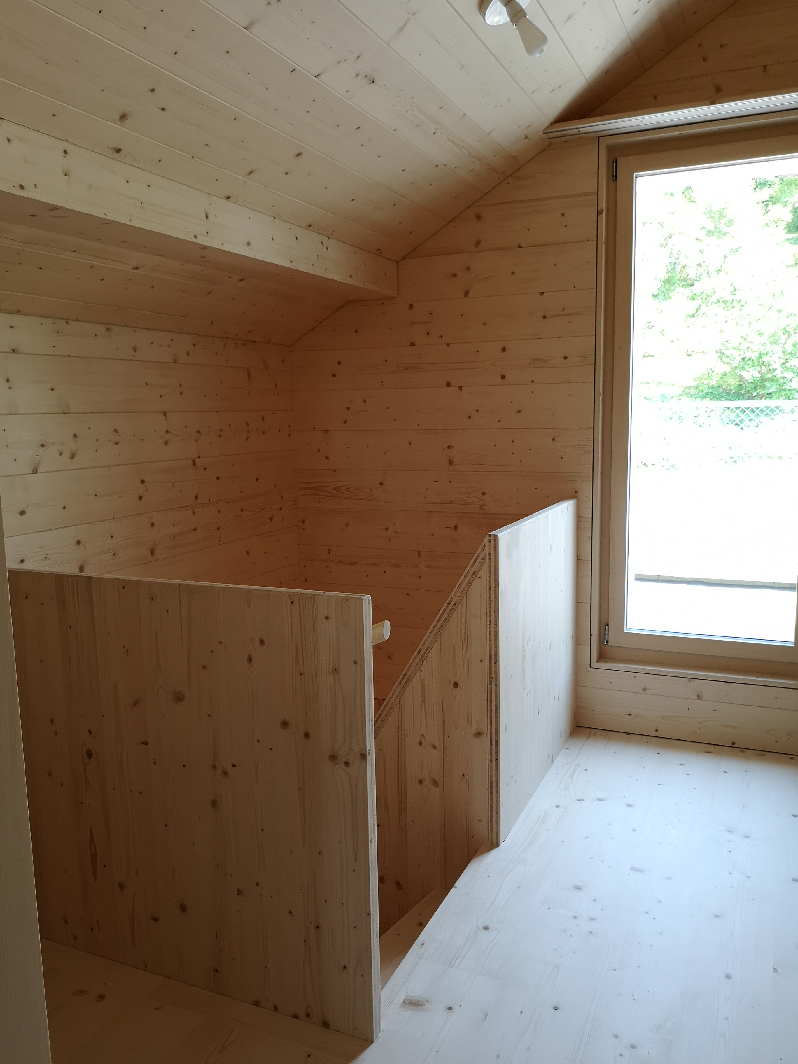 Holzverkleideter Dachraum mit Fenster und Treppe