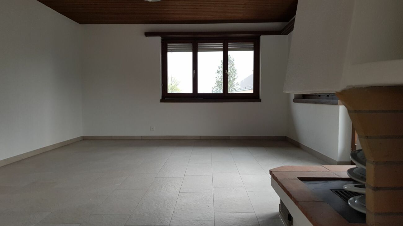 Leerer Wohnraum mit Fenster und Kamin