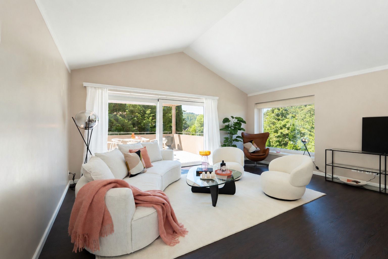 Helles, modern eingerichtetes Wohnzimmer mit Terrasse und Grünblick